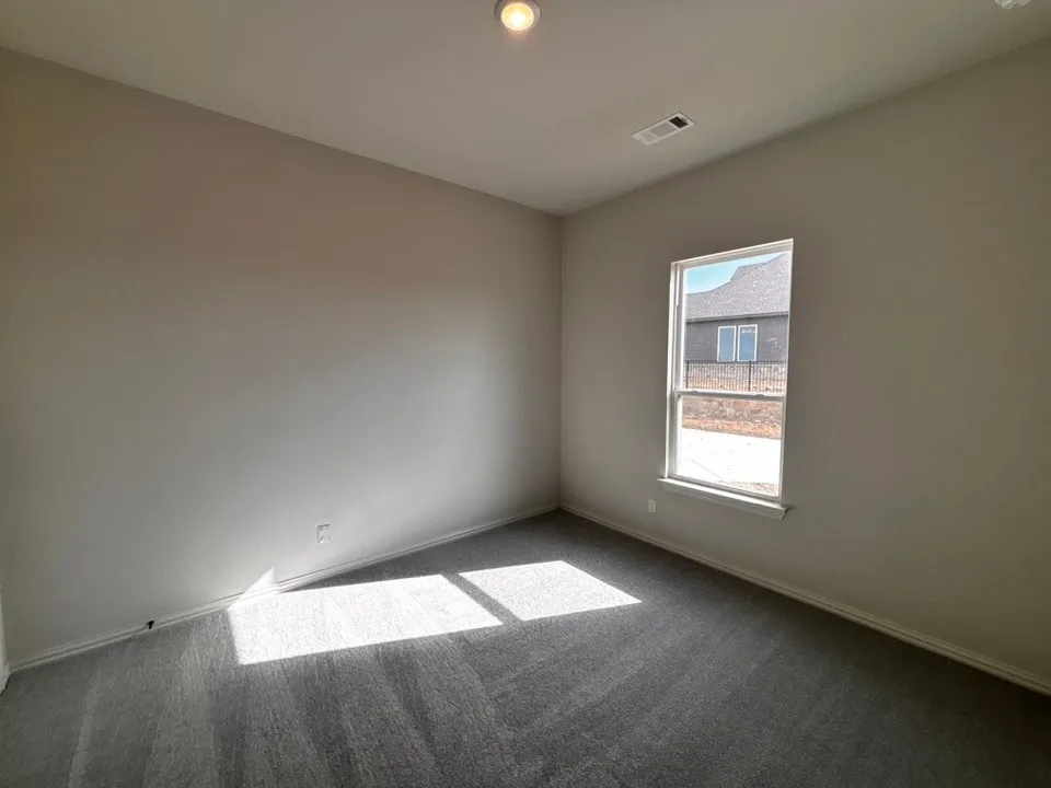 Recessed ceiling light, neutral wall paint, single window, gray carpet, and white trim