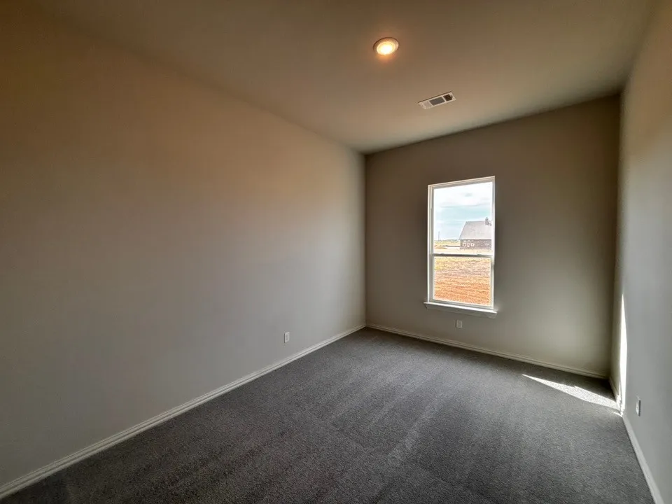 Recessed lighting, neutral wall paint, carpeted flooring, and a single pane window