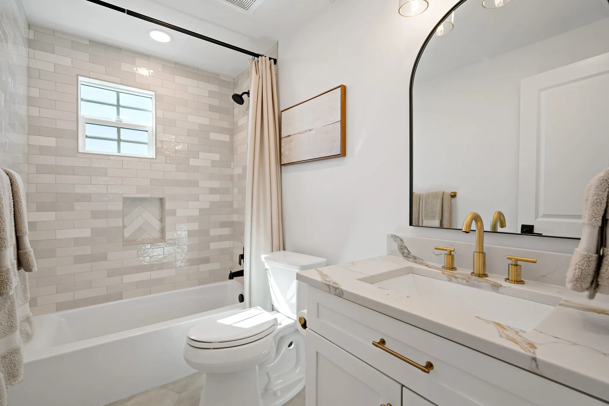 Contemporary vanity with a rectangular undermount sink, gold-tone hardware, and a marble-patterned countertop