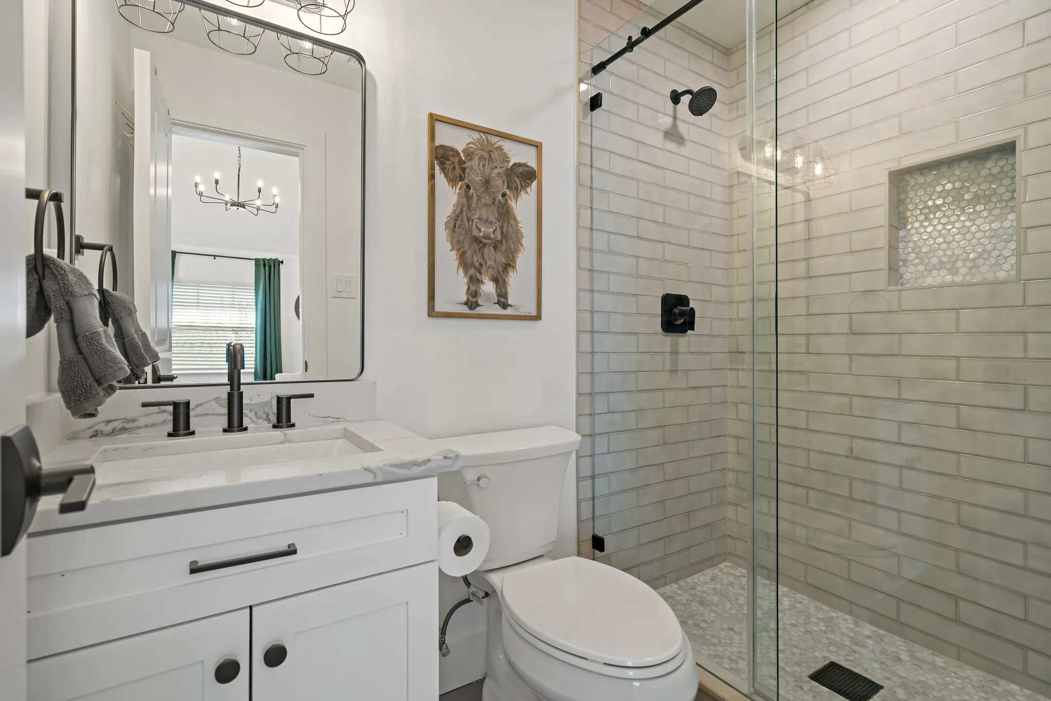 White vanity with a stone countertop and matte black fixtures