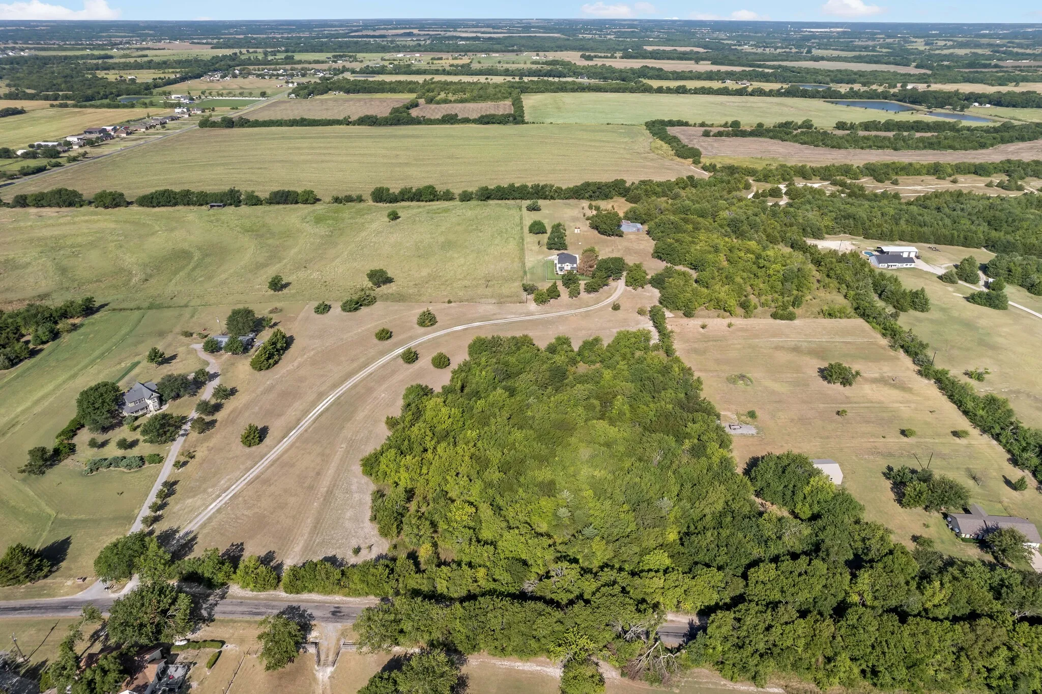 Expansive acreage featuring a mix of open fields and mature tree coverage