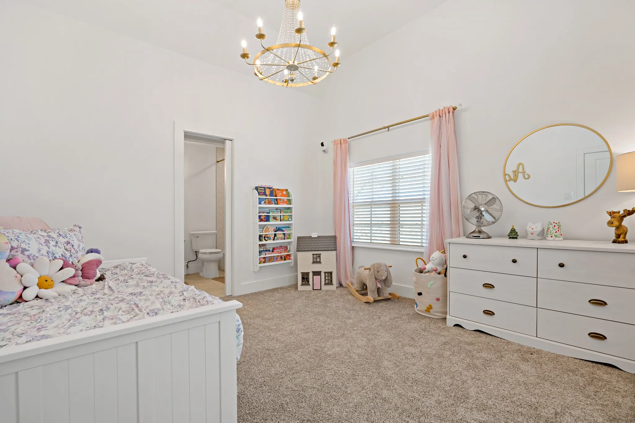 Vaulted ceiling with an ornate chandelier, carpeted flooring, and a window featuring blinds