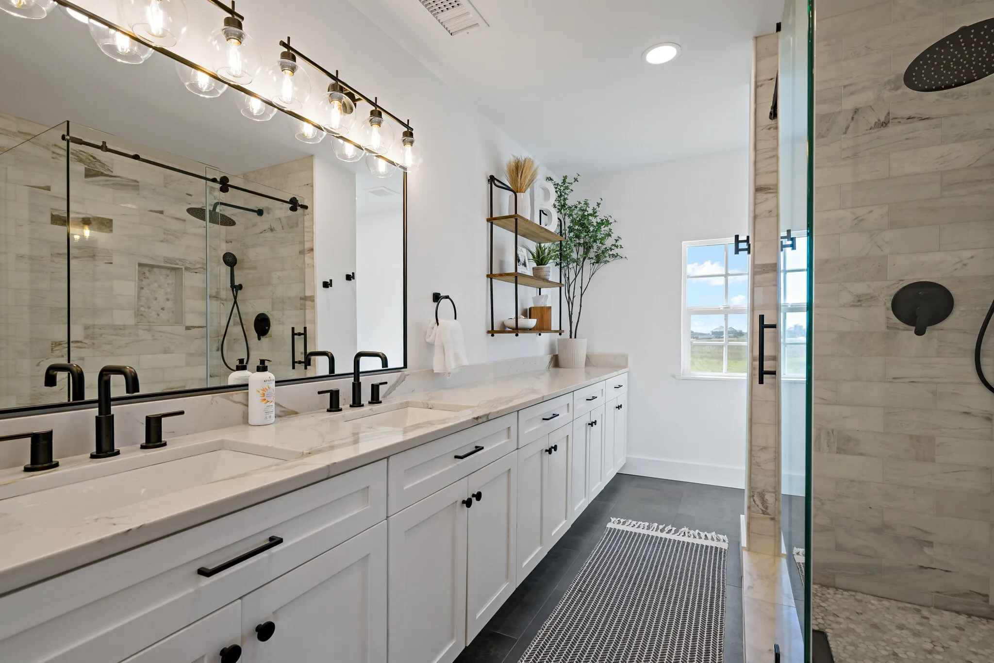 Dual vanity with integrated sinks, white cabinetry, and light-toned countertops.