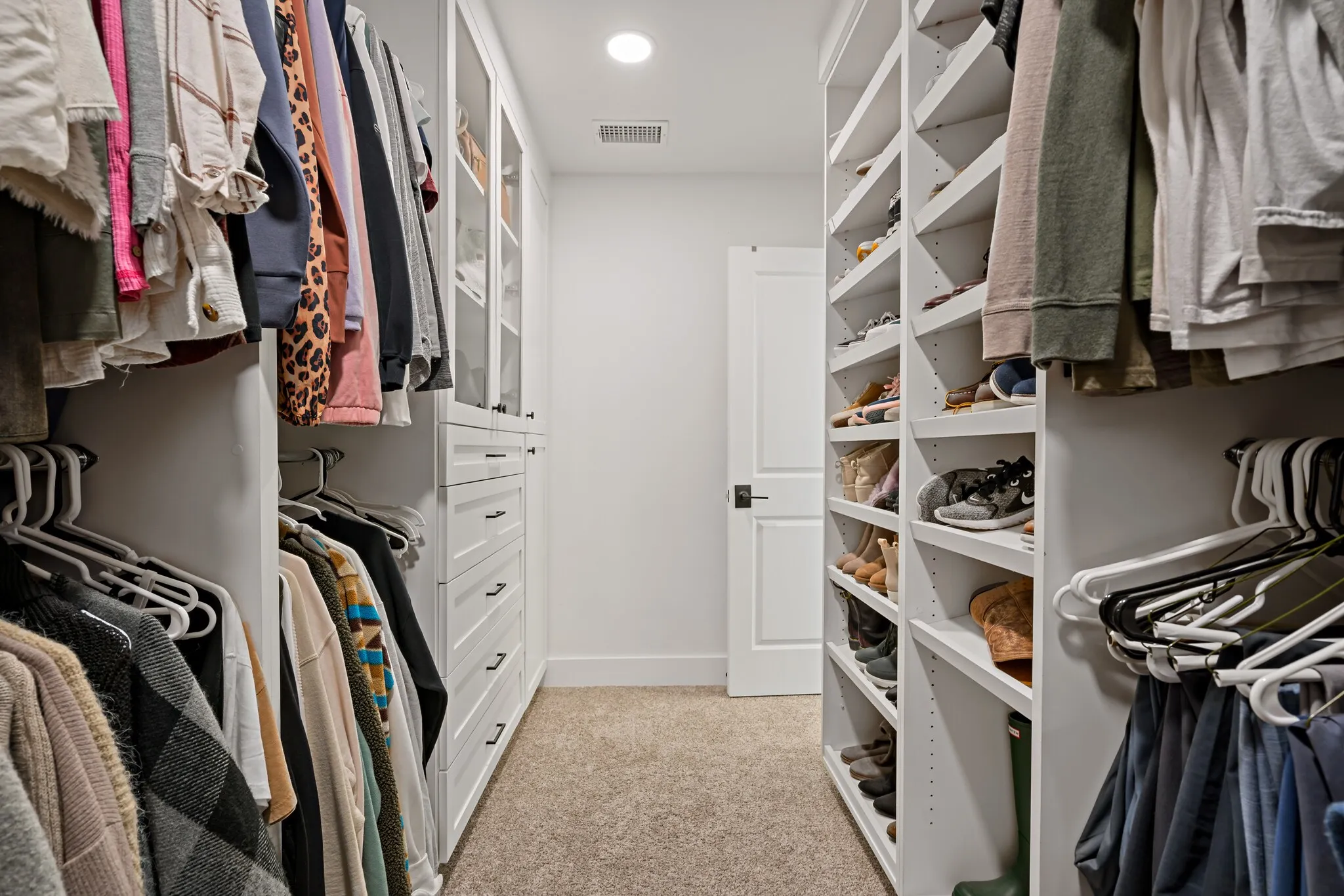 Custom built-in closet system featuring multiple hanging rods, integrated shelving, and drawer storage