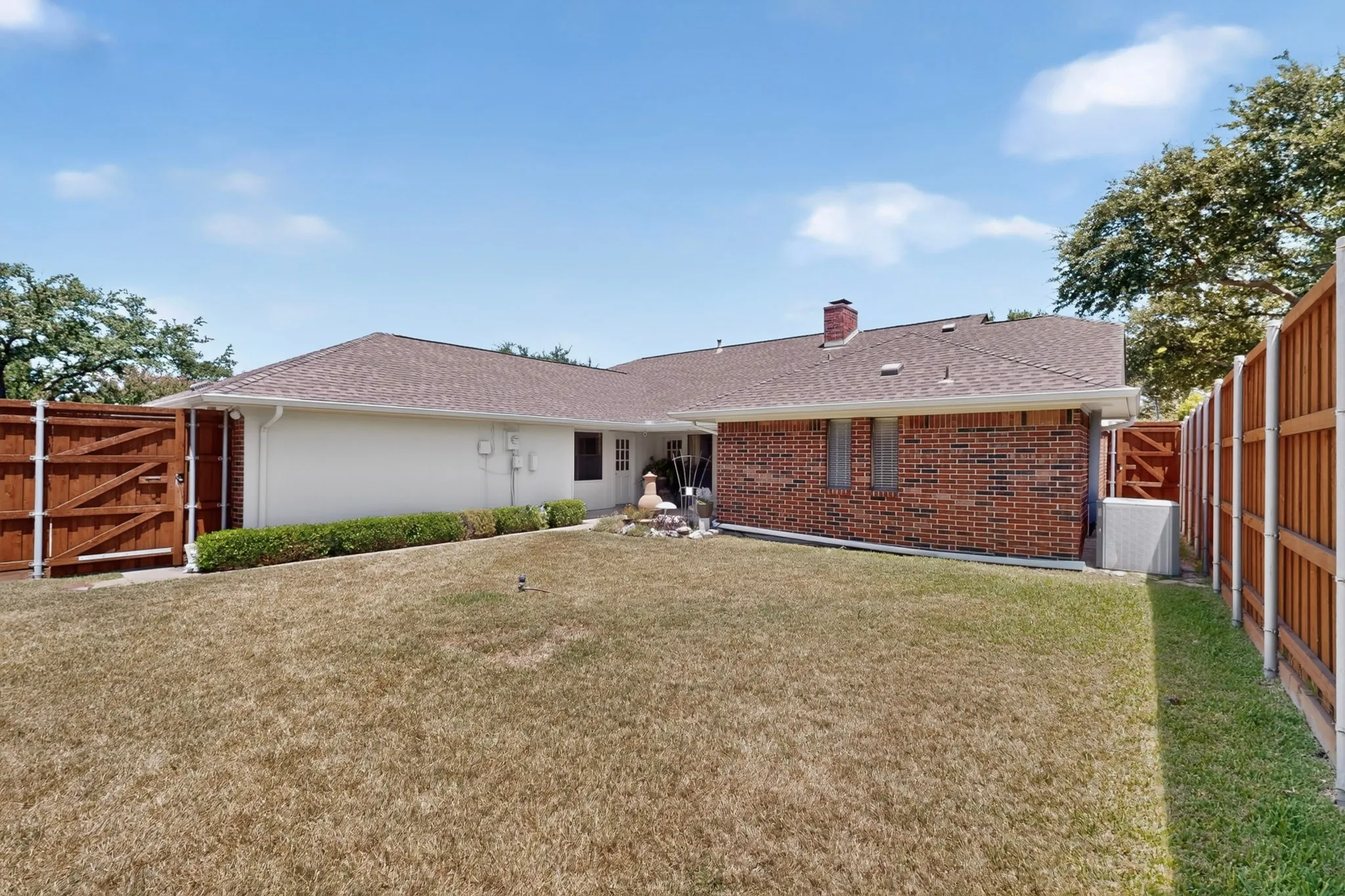 Spacious backyard with mature landscaping and wooden privacy fencing on both sides