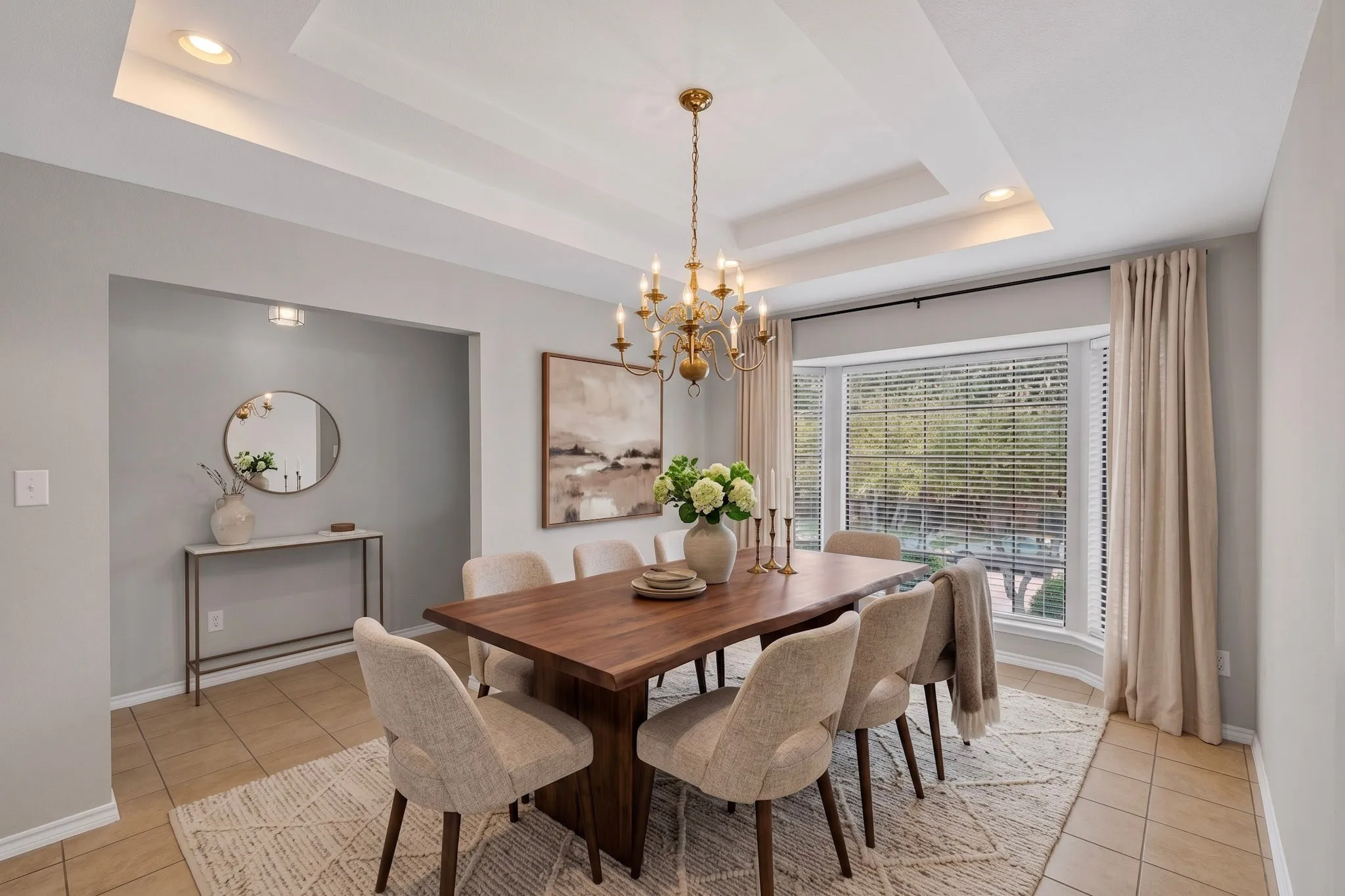 Tray ceiling with recessed lighting and a brass chandelier
