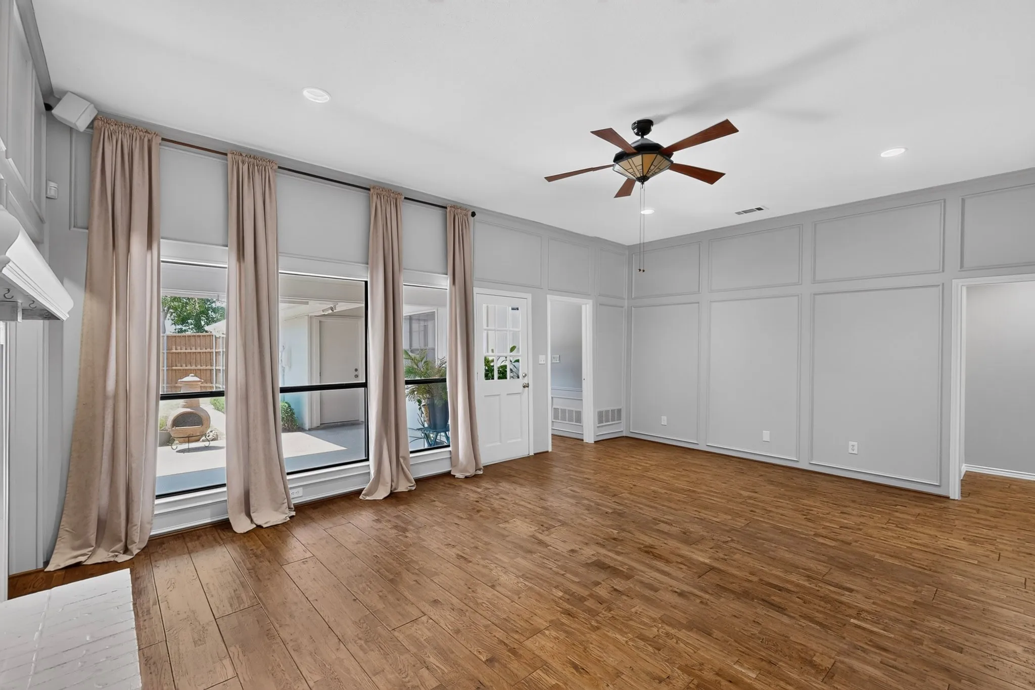 Spacious living area with wall of windows overlooking backyard