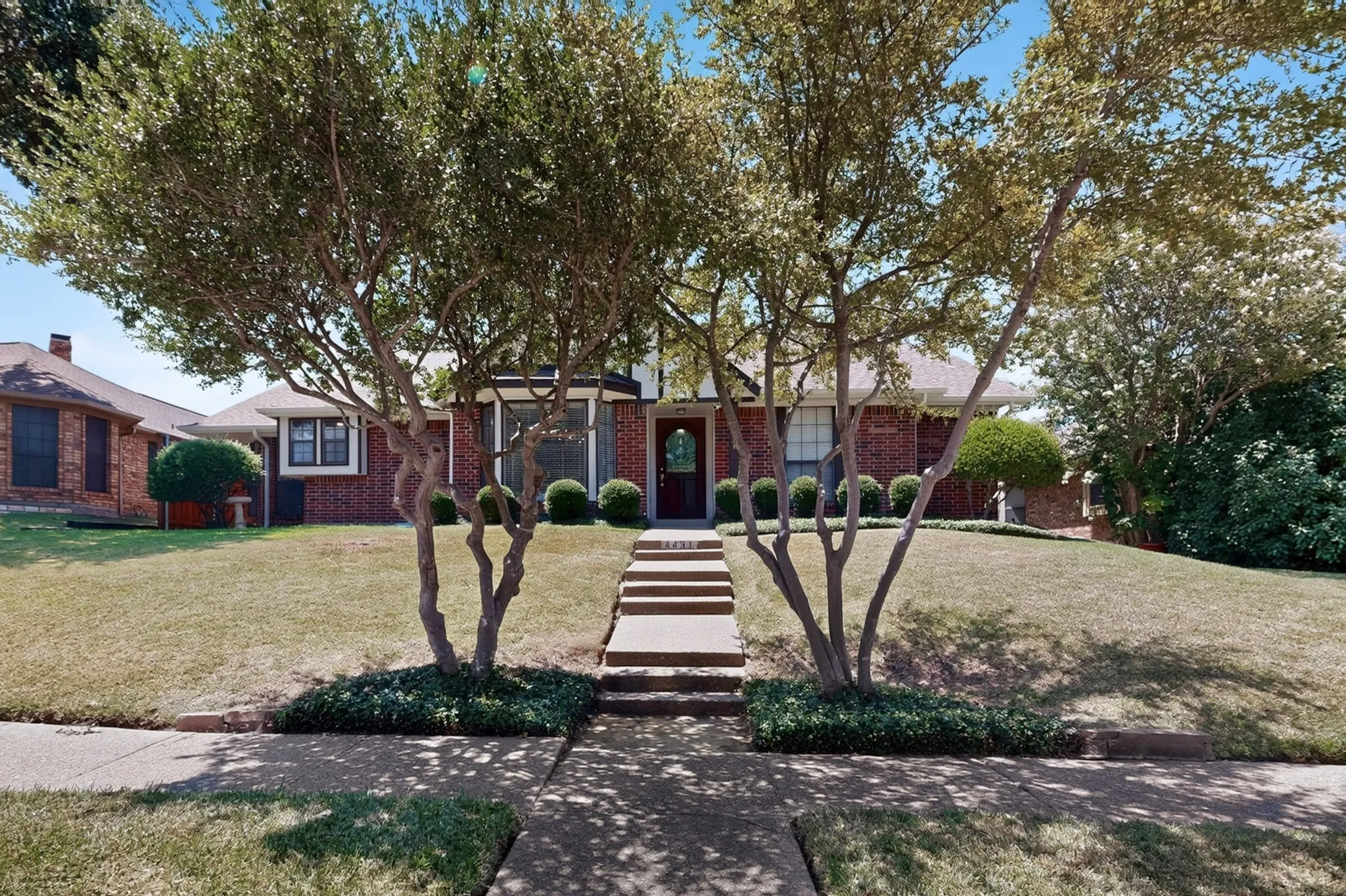 Charming brick residence with mature landscaping and manicured lawn