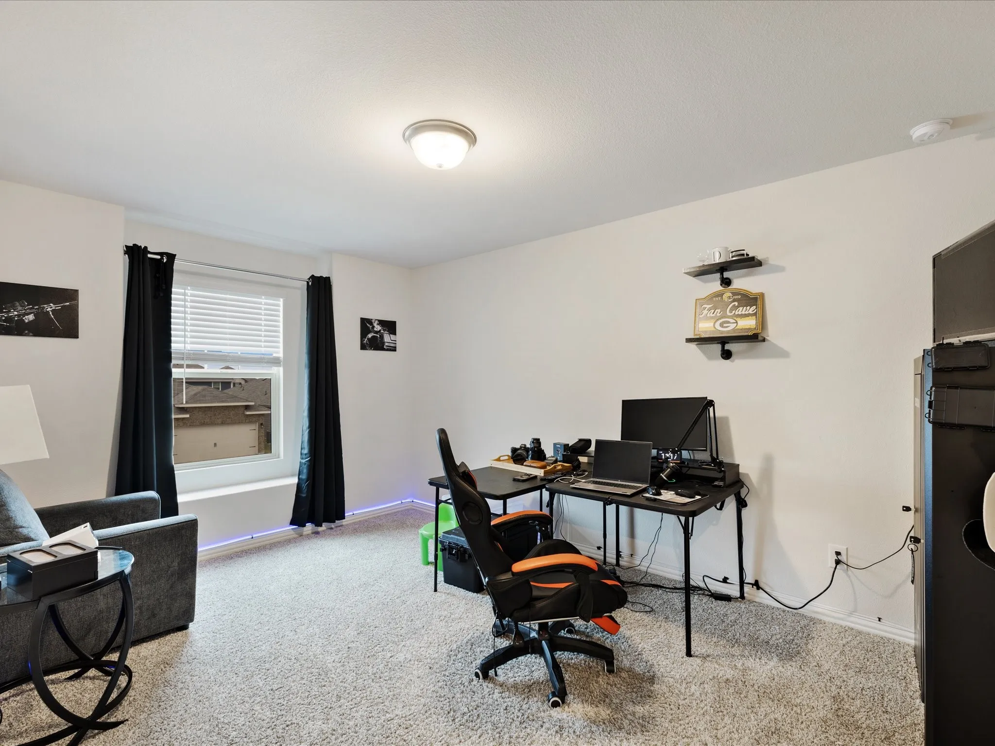 Carpeted flooring, white walls, window with blinds, overhead lighting, built-in shelving