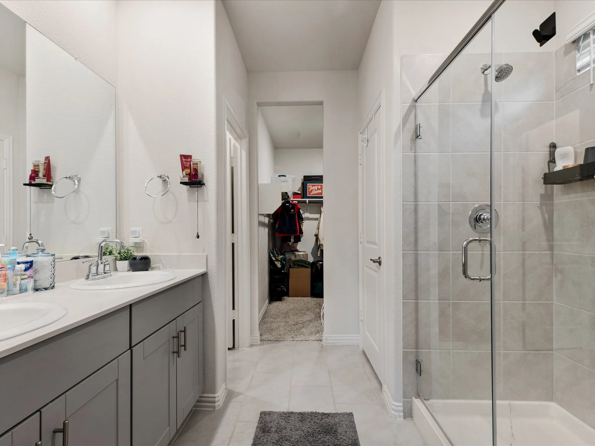 Dual vanity with a stone-finish countertop, undermount sinks, and grey cabinetry