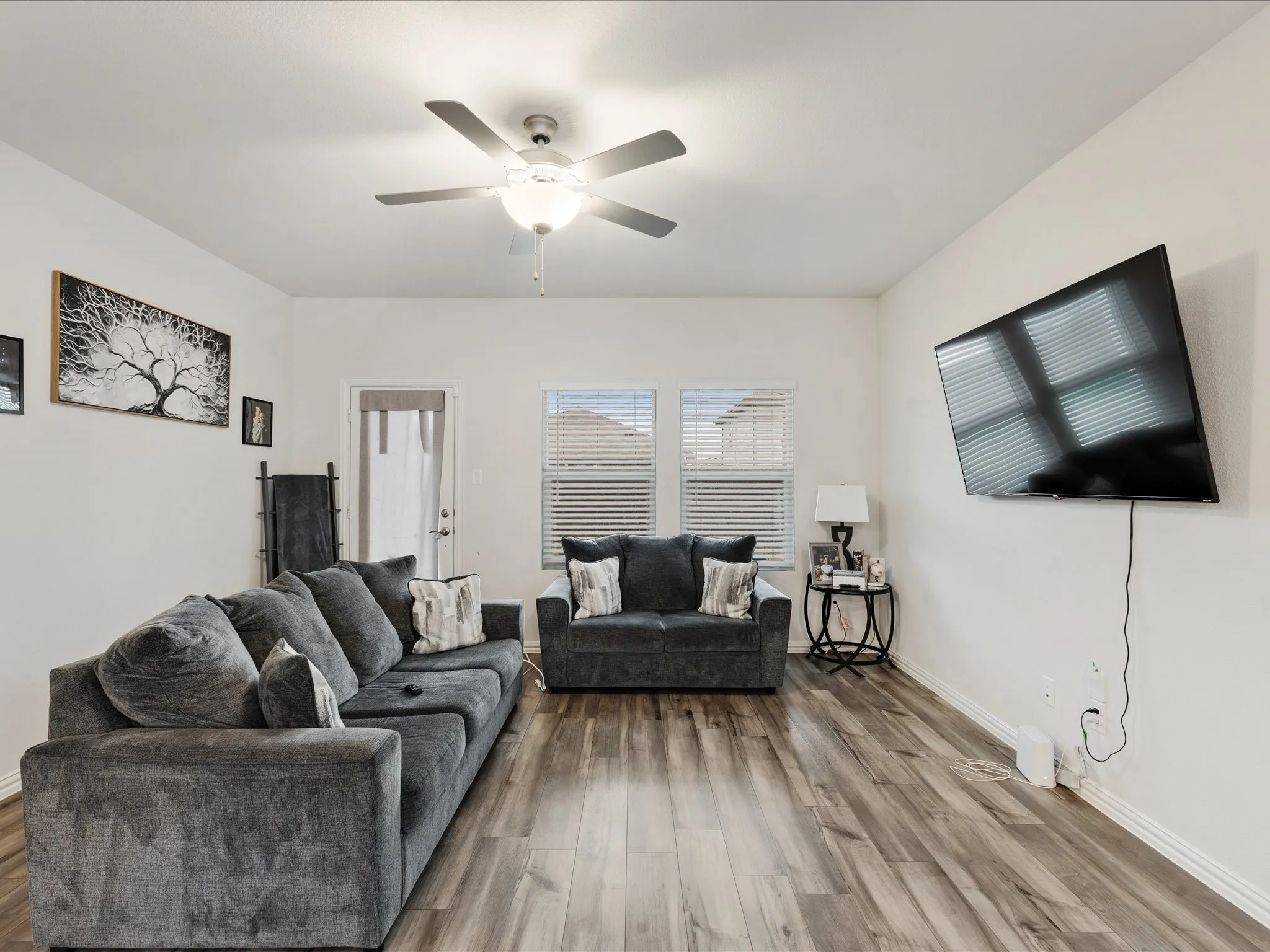 Recessed lighting, wood-finish flooring, ceiling fan, multiple windows with blinds, and a rear door with an upper window