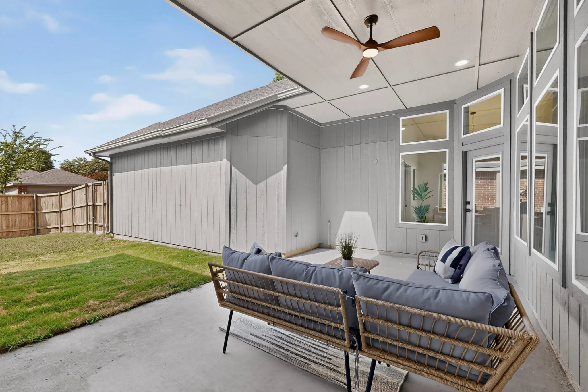 Covered patio featuring a wood-finish ceiling fan, recessed lighting, and an expansive concrete slab
