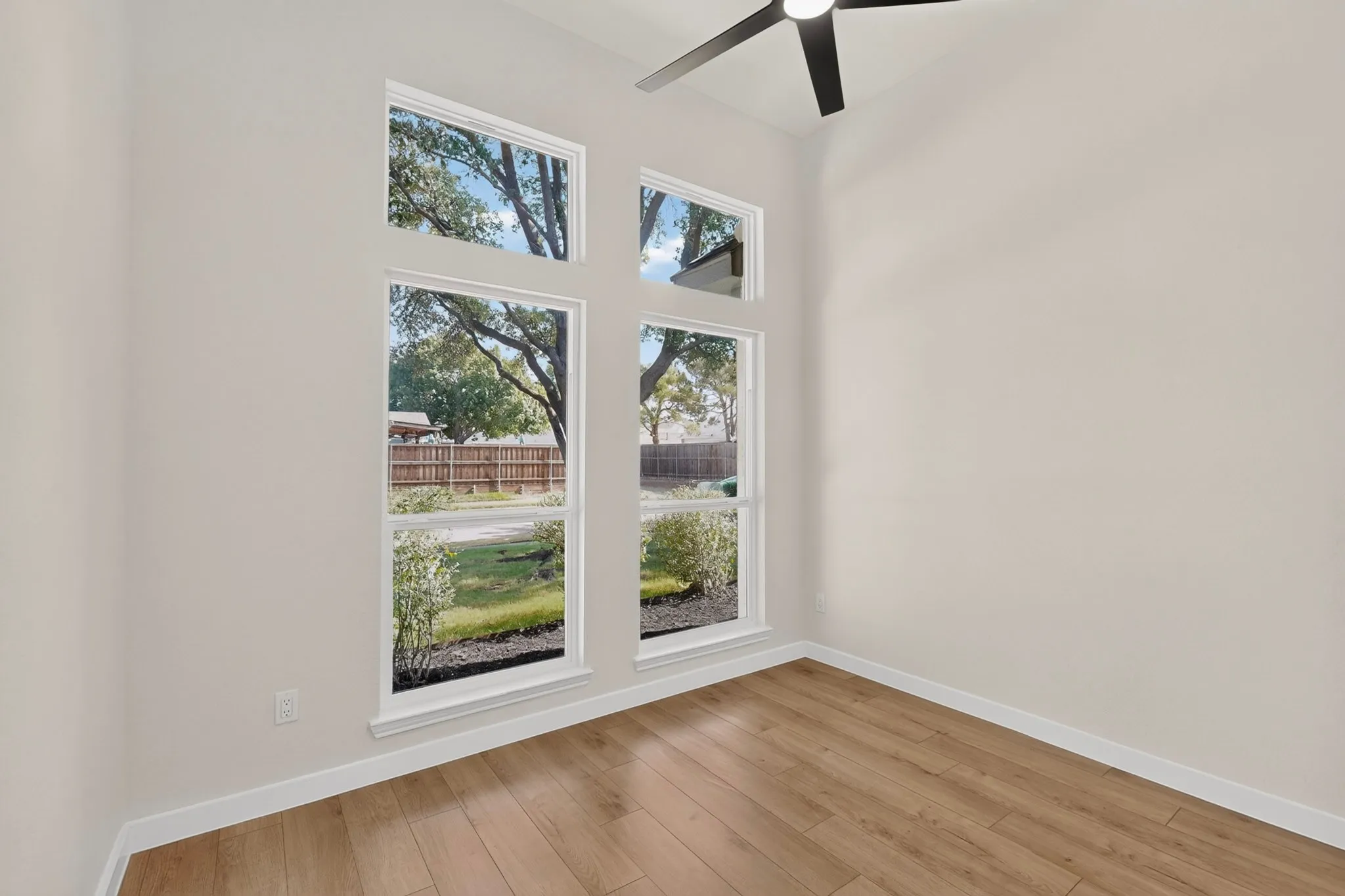 Vaulted ceilings, wood-finish flooring, and multiple windows providing ambient light