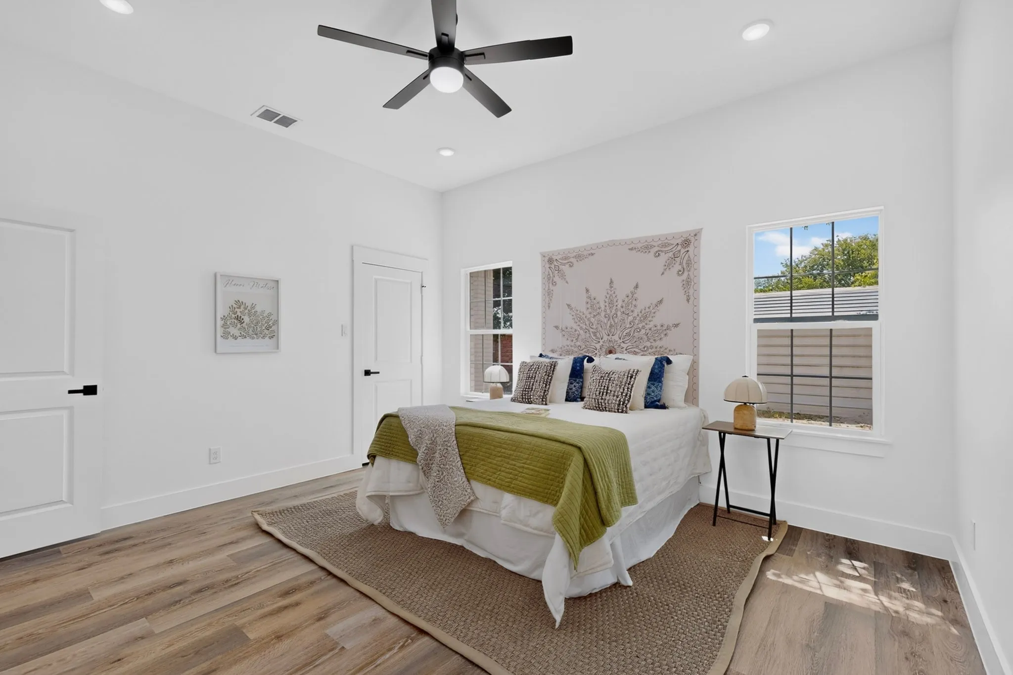 Wood-finish flooring, white walls, and a ceiling fan with integrated lighting