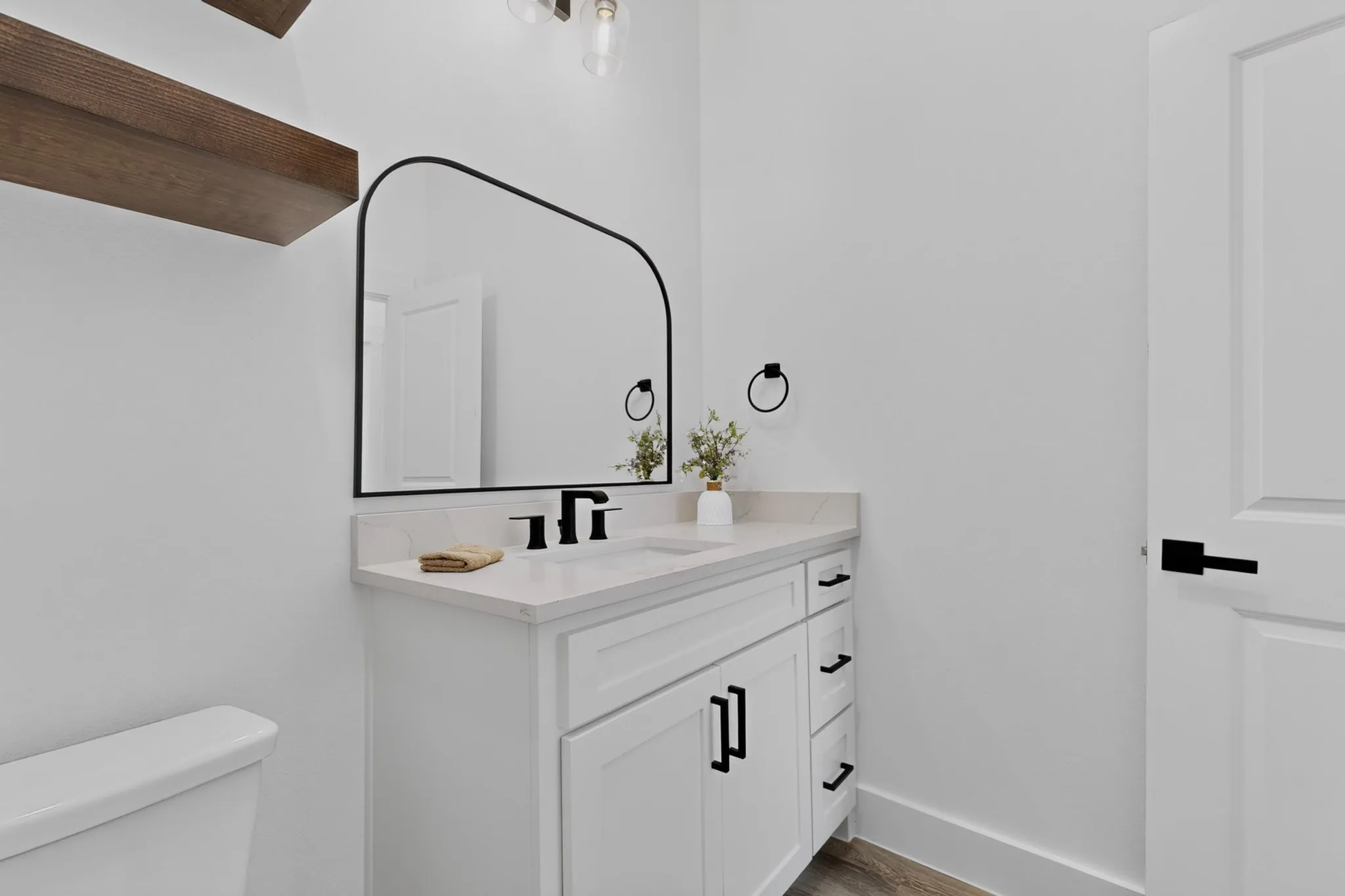 White vanity with matte black hardware and a white countertop