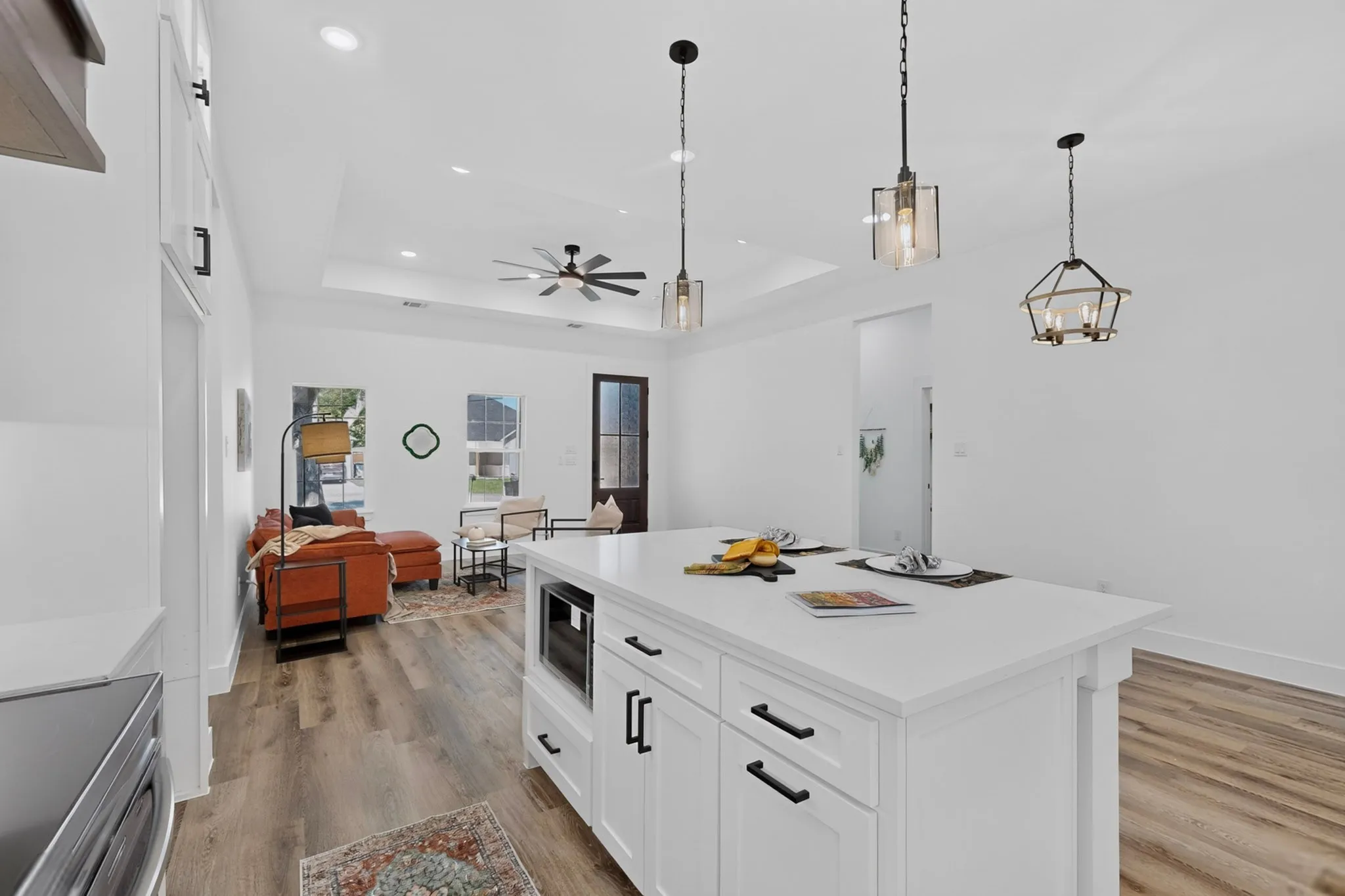 Spacious kitchen island with white cabinetry and integrated microwave