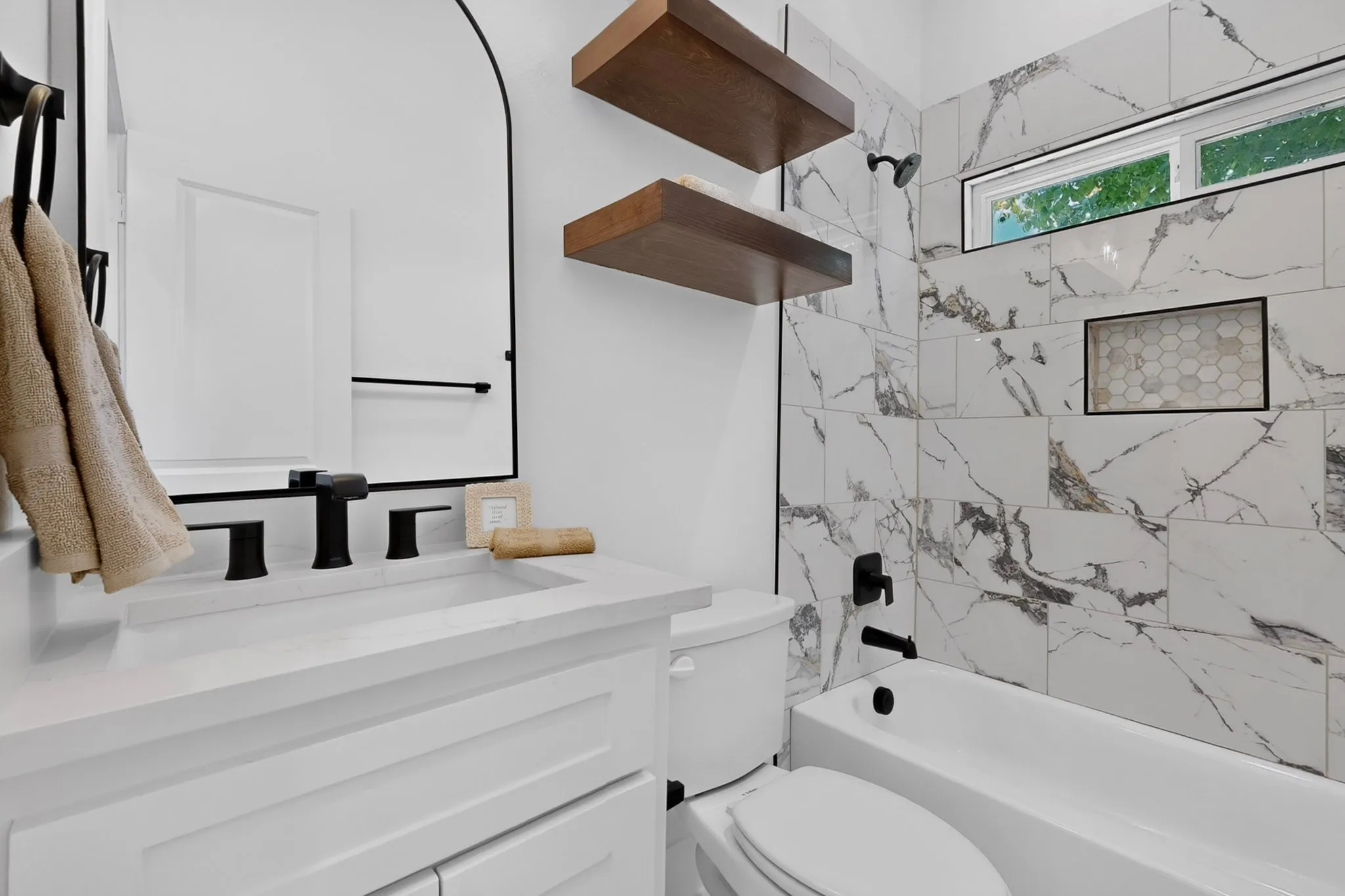 White vanity with a rectangular sink and matte black hardware