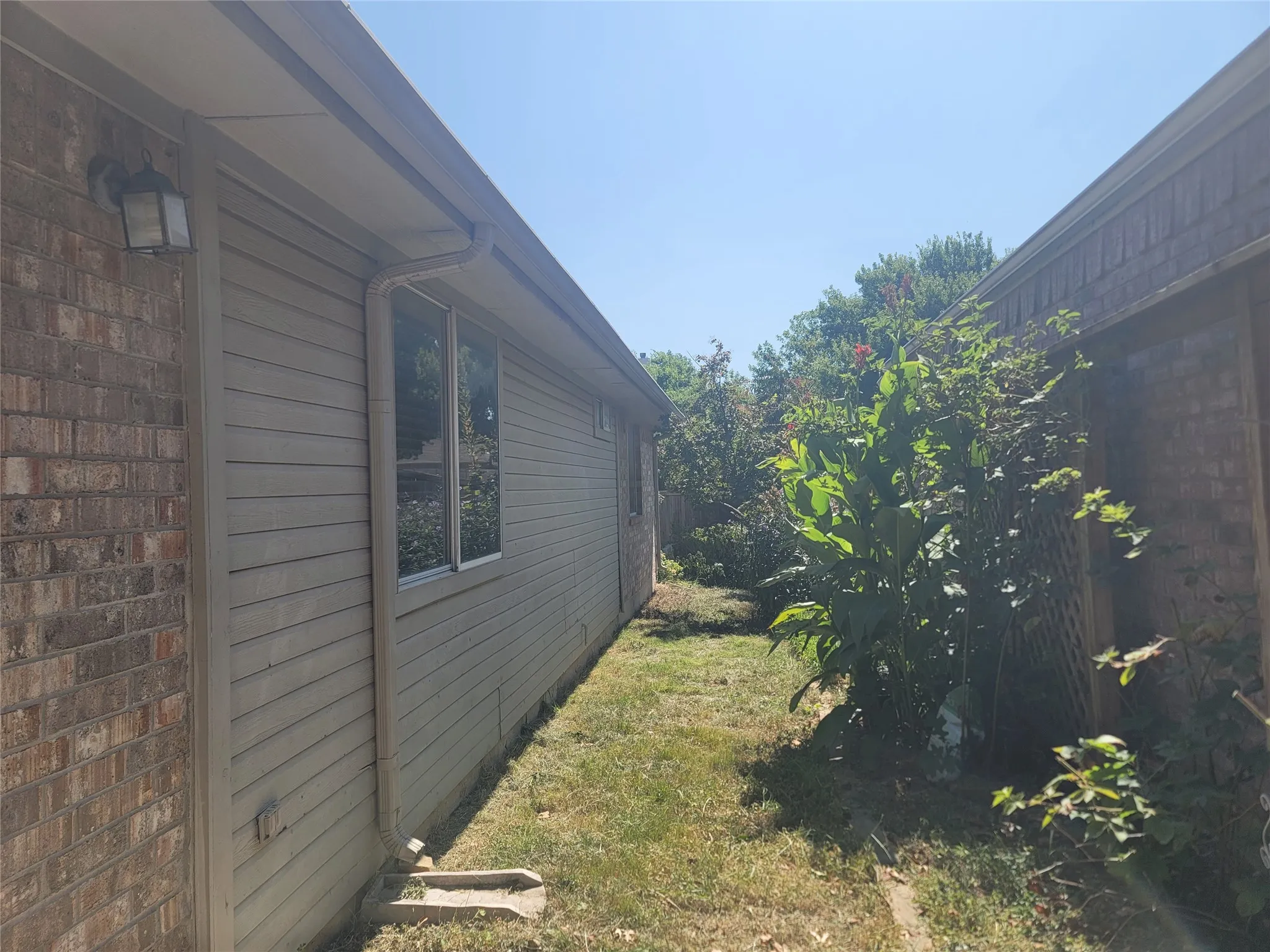 Exterior siding with brick accents and a window
