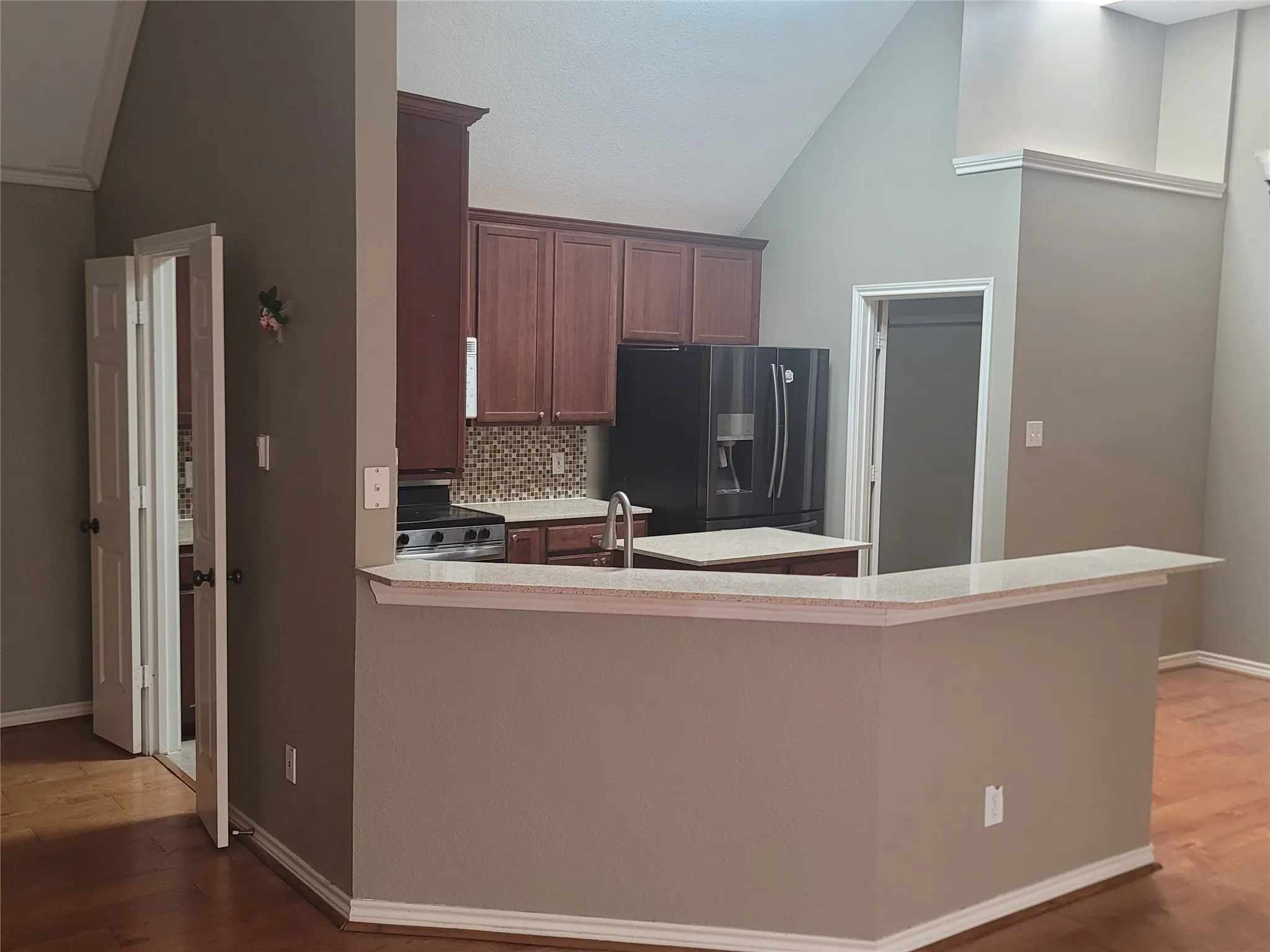 Kitchen featuring wood-finish cabinetry, light-toned countertops, and a mosaic tile backsplash