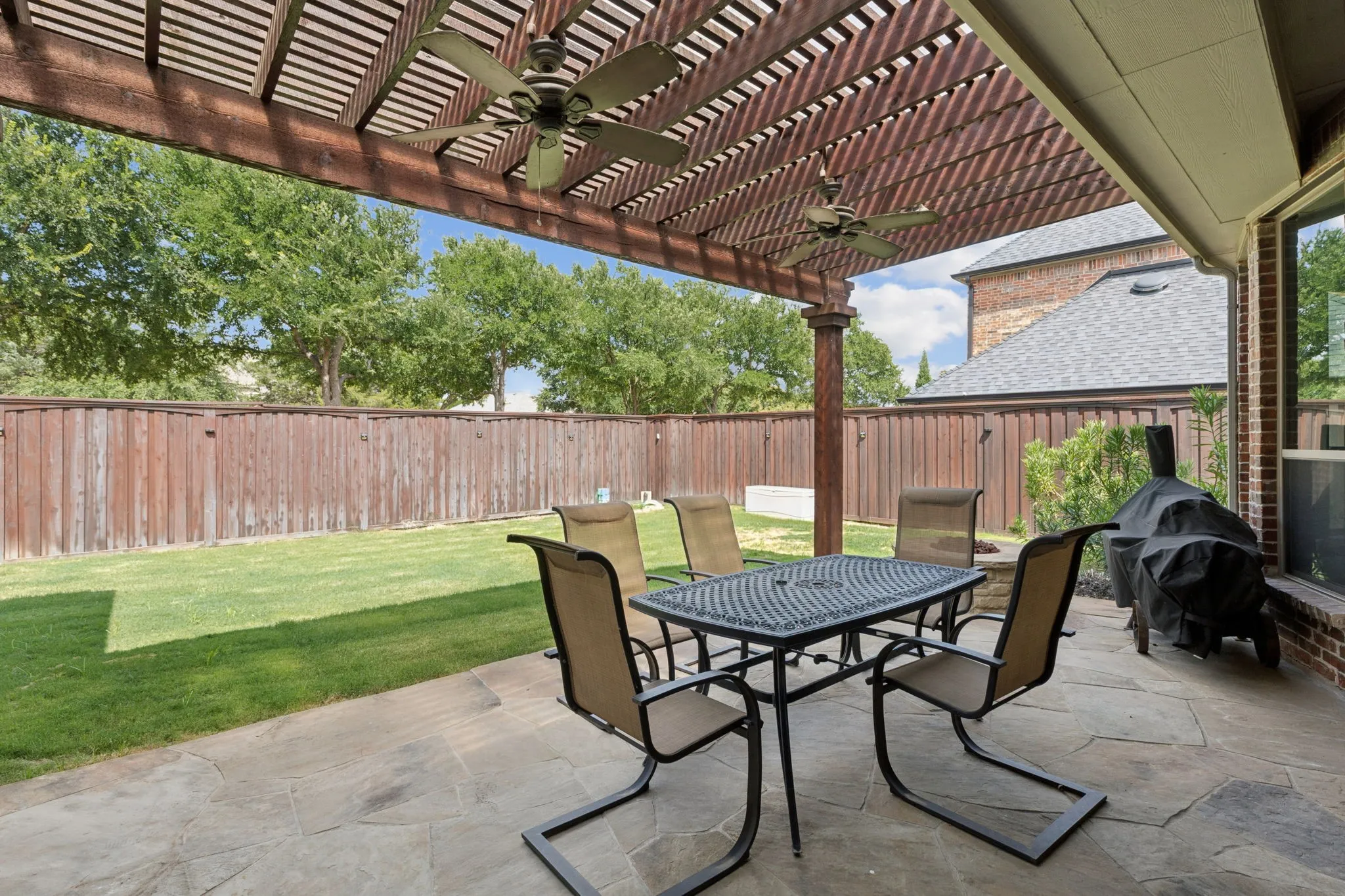 Expansive patio with stone flooring and a large wood pergola