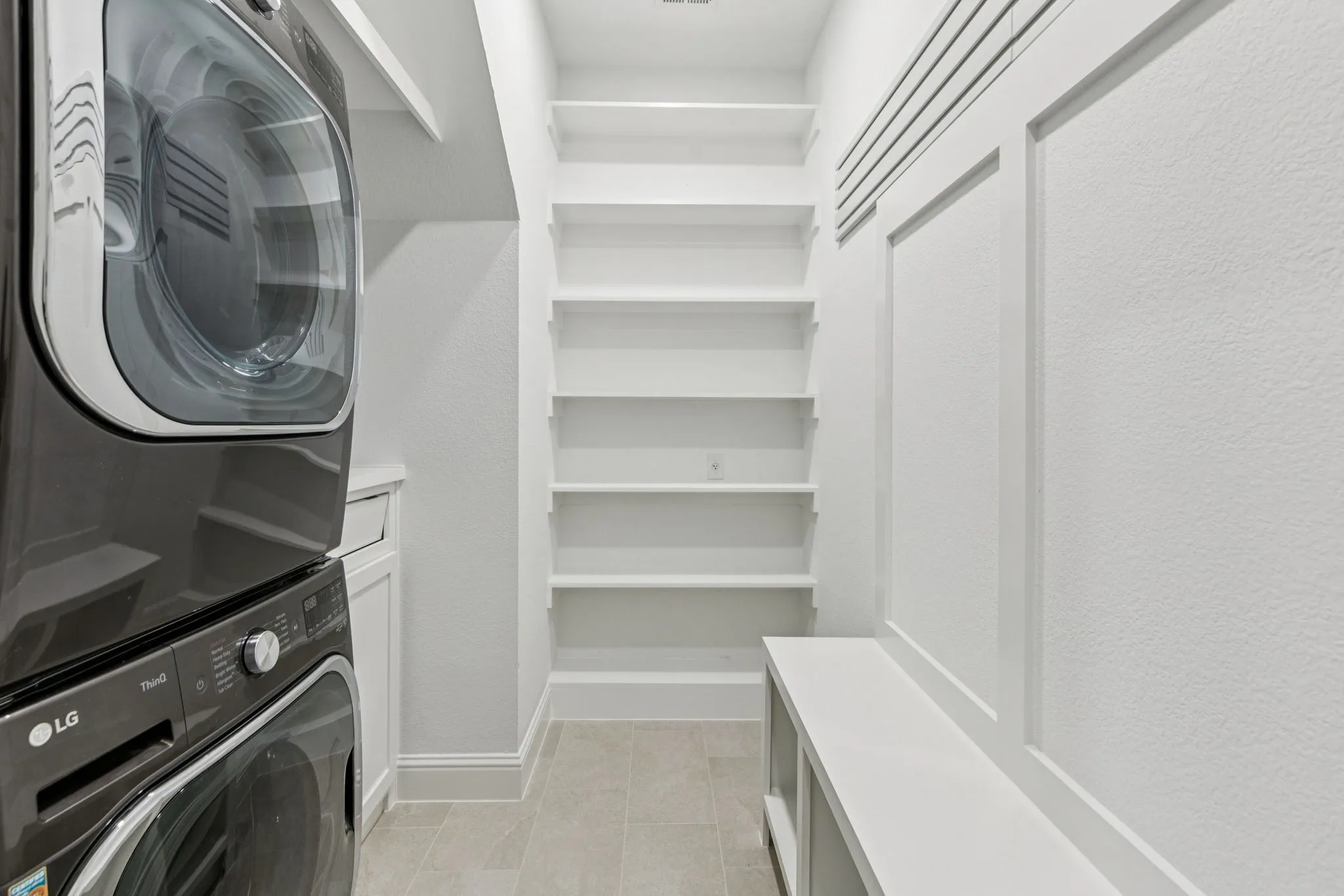 Built-in shelving, tile flooring, built-in bench, and wainscoting details