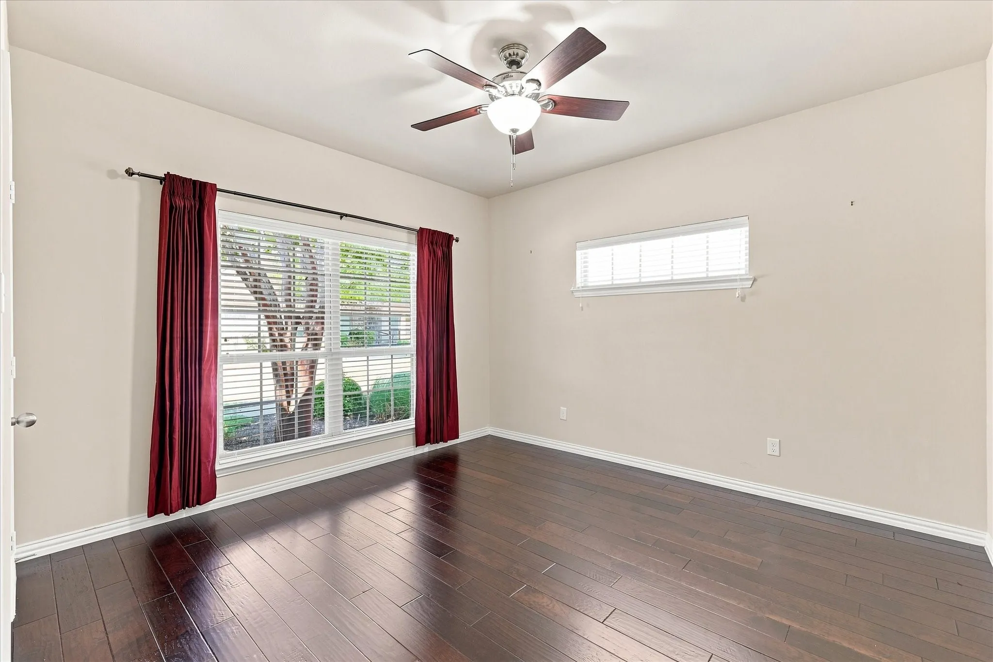 Here, the secondary bedroom is shown again without virtual staging to highlight the beautiful wood floors and versatility of the space. With plenty of room to furnish and personalize, it can easily adapt to a guest room, office, hobby space, or whatever best fits your lifestyle.