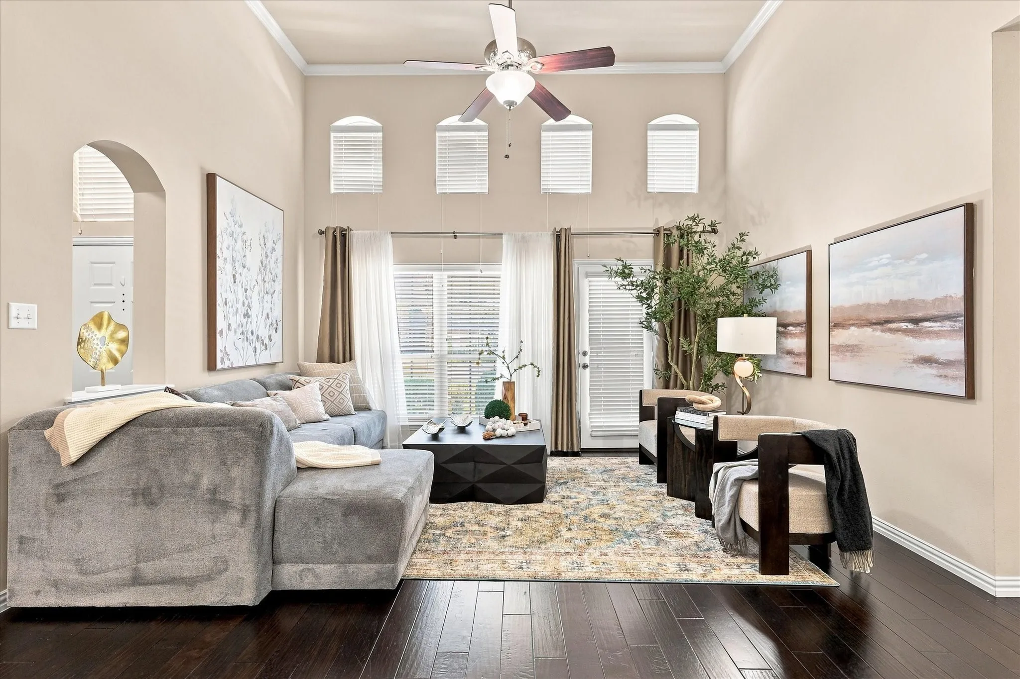 A wall of windows fills the living room with natural light, while the glass door provides direct access to the private patio, creating an easy connection between indoor and outdoor living.