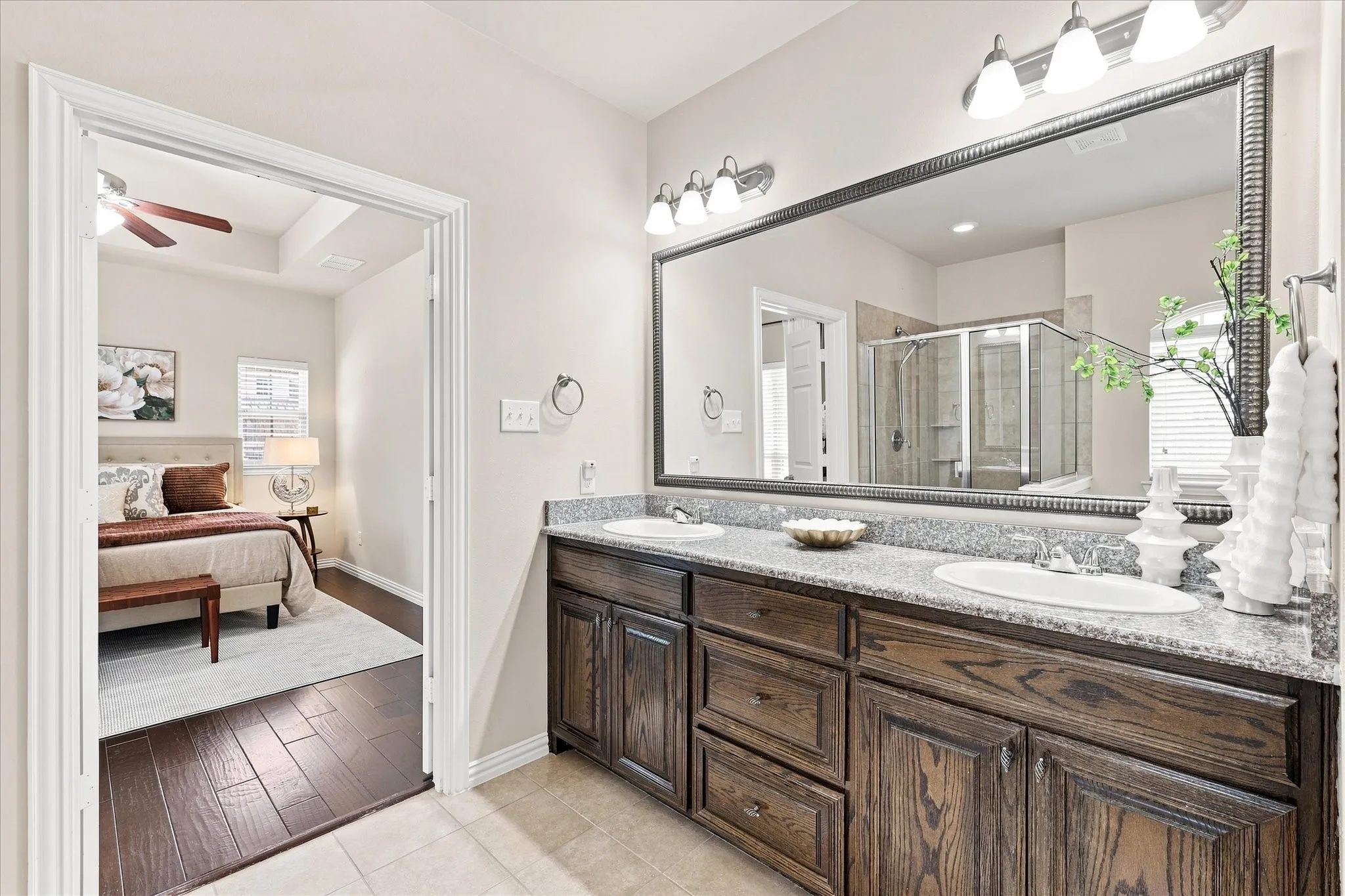 The primary bathroom features dual sinks with granite countertops, offering a spacious and functional setup for everyday living.