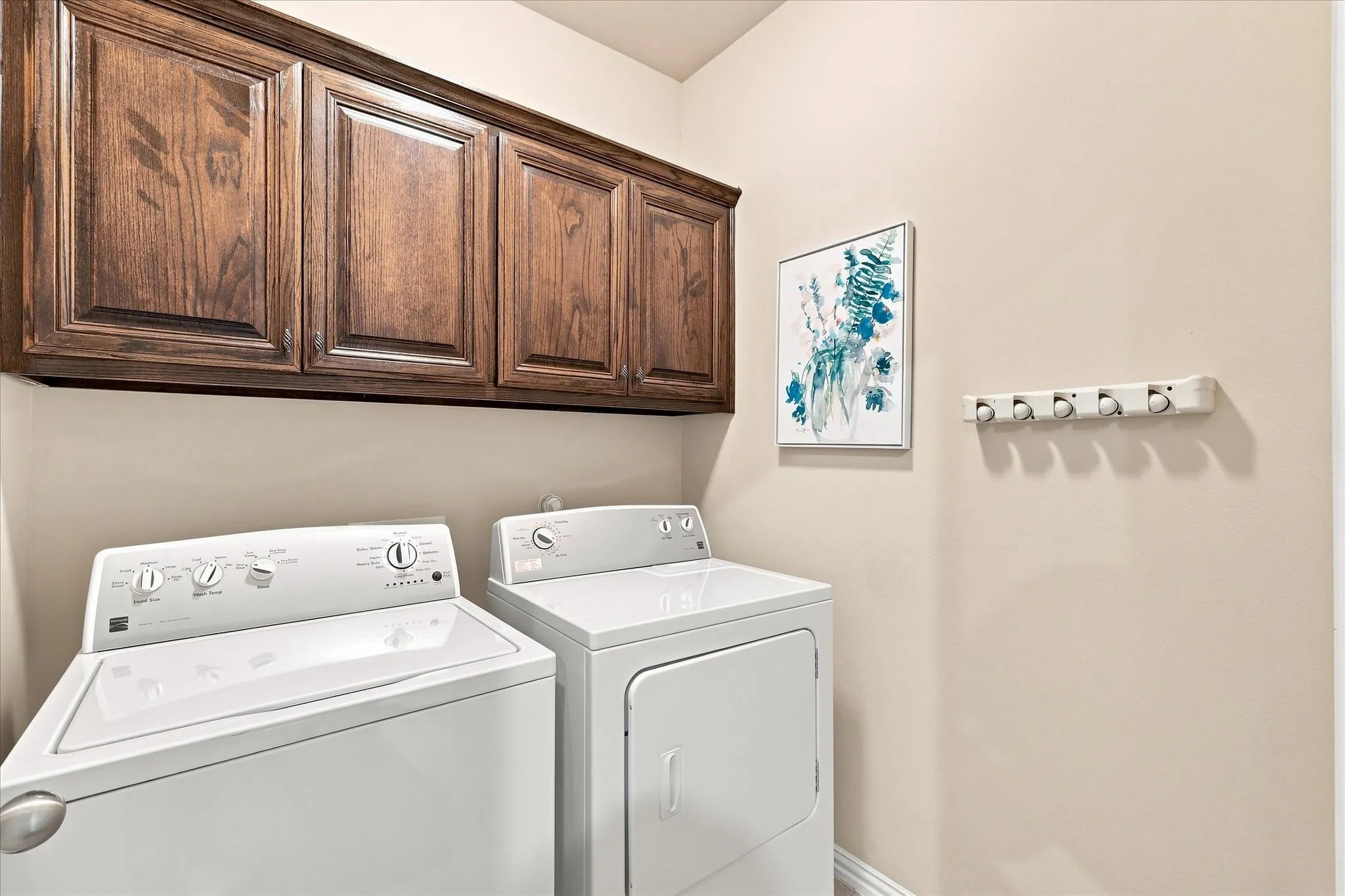 The laundry room features built-in cabinetry, providing convenient storage and helping keep everyday essentials organized and out of sight