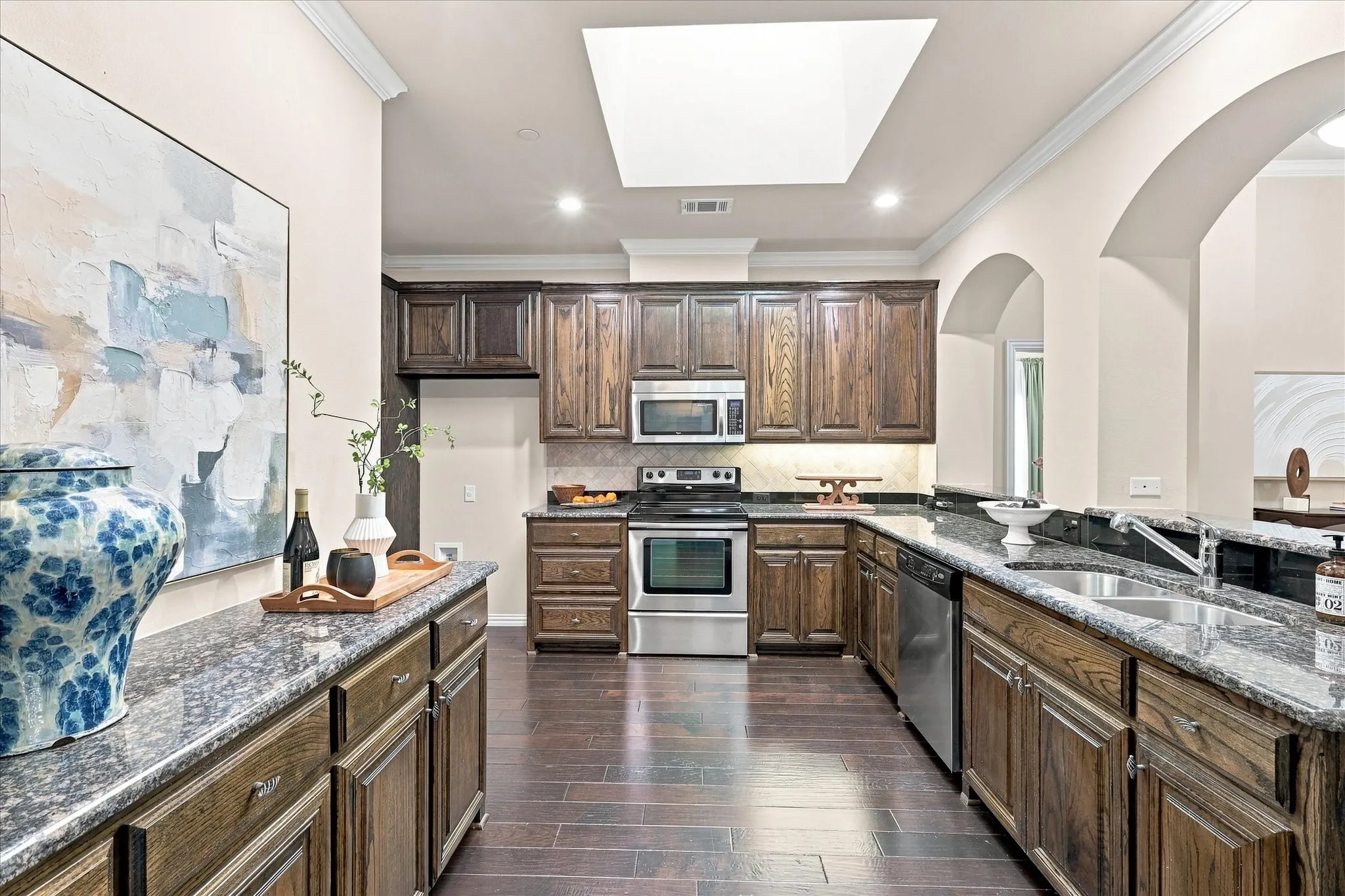 The kitchen offers generous cabinet space and a skylight that brings in beautiful natural light, creating a warm and inviting space for everyday cooking and gathering.