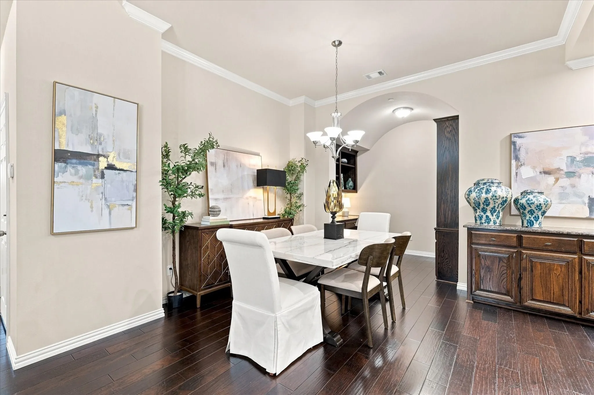 The open floor plan seamlessly connects the living room, dining area, and kitchen, creating an inviting space that makes everyday living and entertaining effortless. Hardwood floors flow throughout the space.