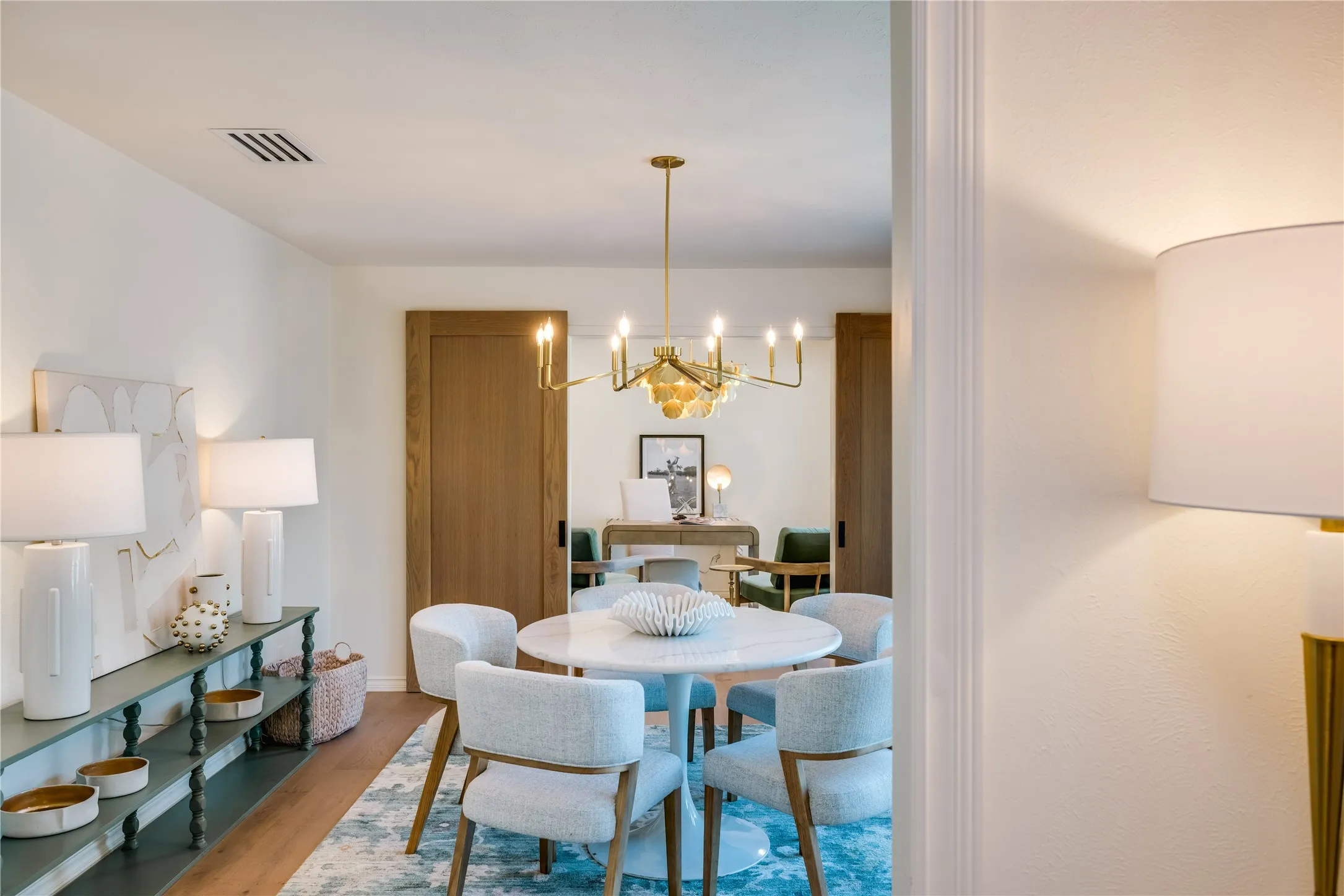 Dining area with wood-finish flooring, and a brass chandelier