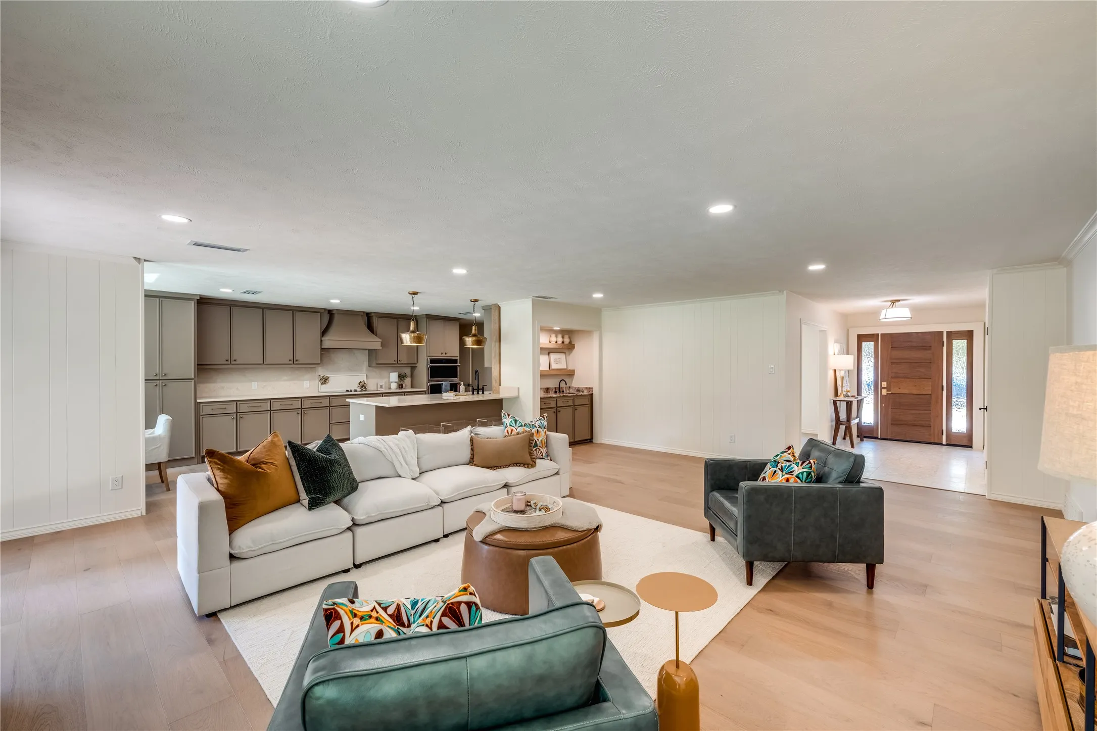 Open-concept living space featuring wood-finish flooring, recessed lighting, and a neutral color palette