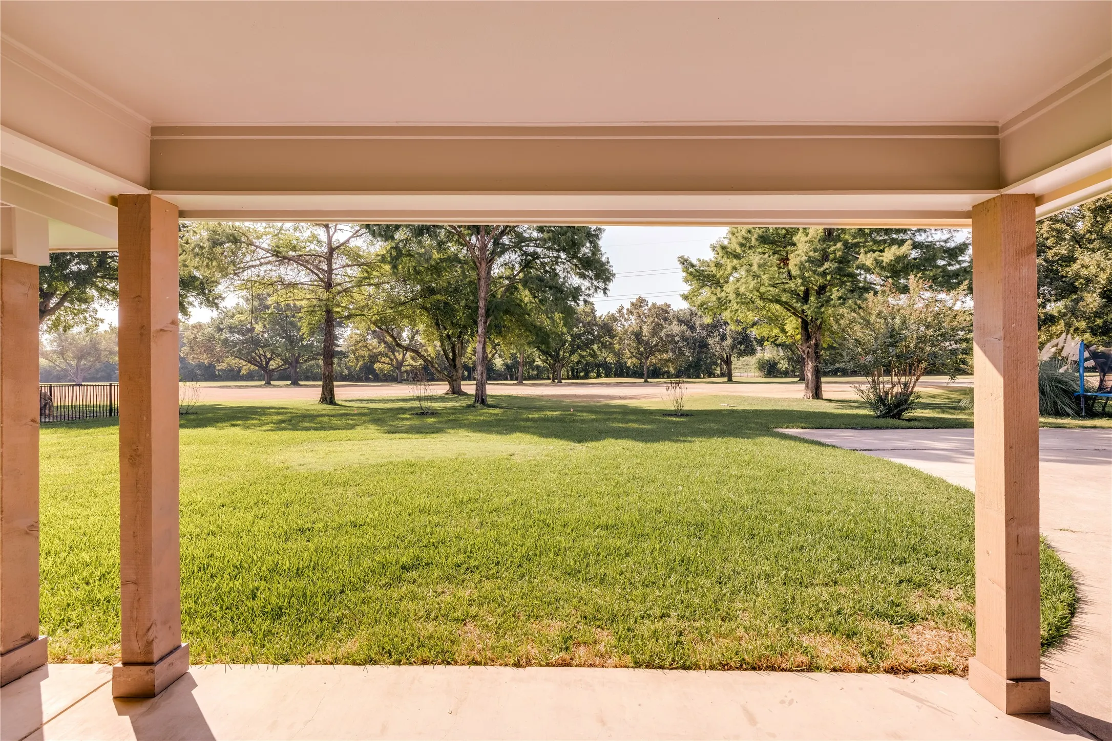 Covered patio with a smooth concrete surface and square support columns