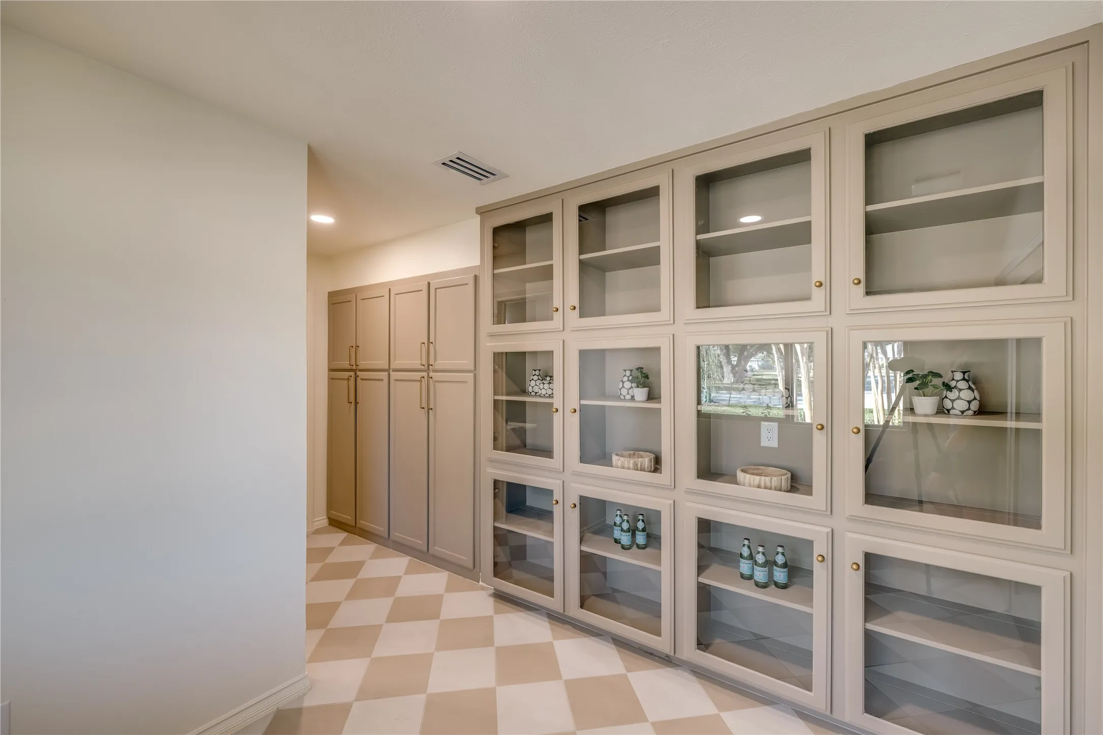 Custom built-in cabinetry with glass-front doors and brass hardware