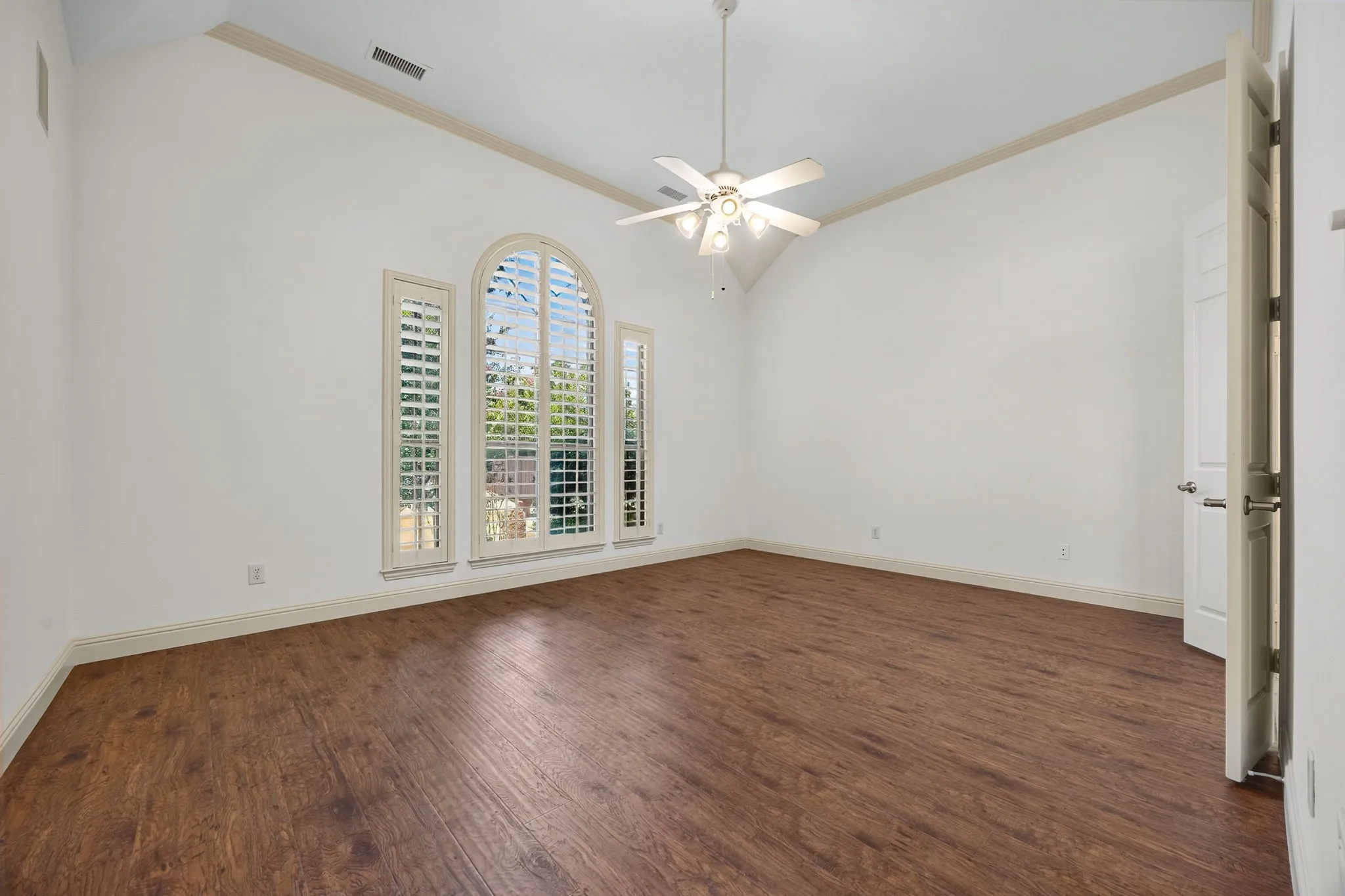 Master bedroom features bay window with shutters and sitting area