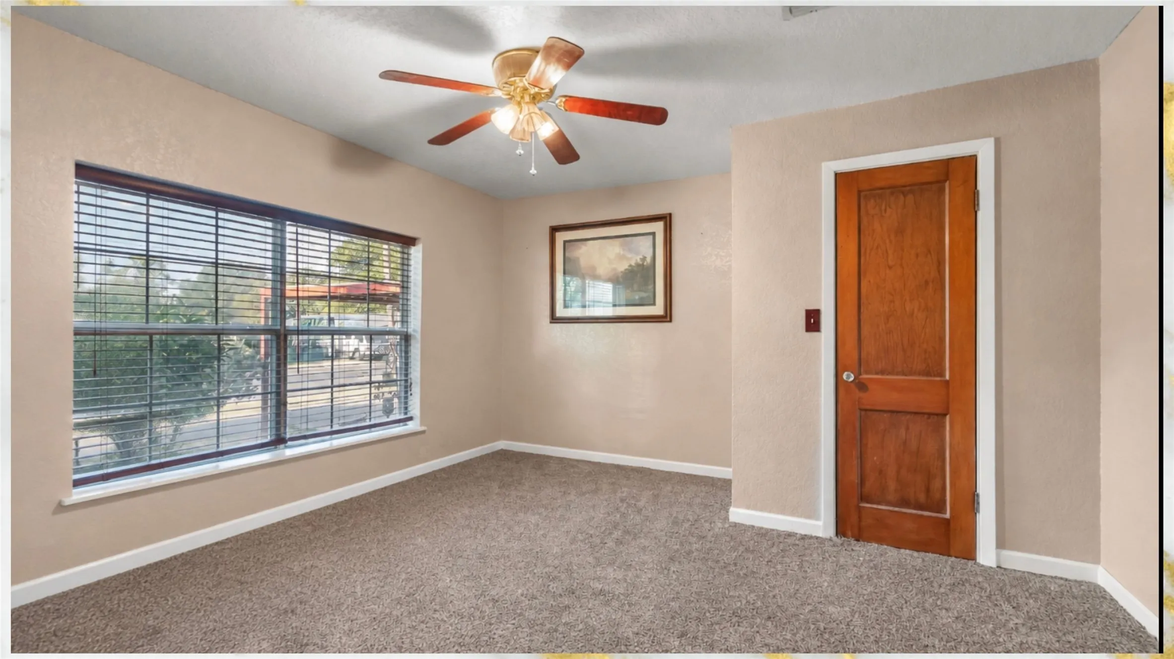 Recessed window with horizontal blinds, carpeted flooring, wood-paneled door, and a ceiling fan with integrated lighting