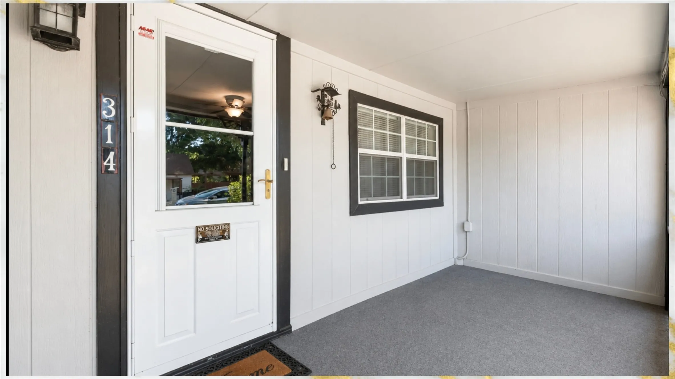 Covered porch entry featuring white vertical paneling, a multi-pane window with dark trim, and a full-light entry door