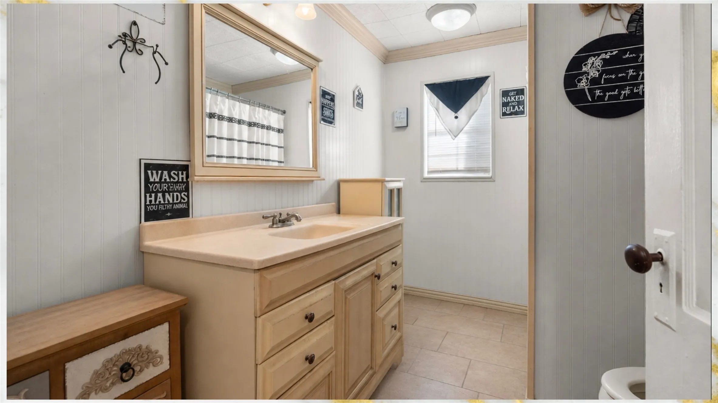 Single vanity with an integrated sink and light-toned countertop, set against a paneled wall