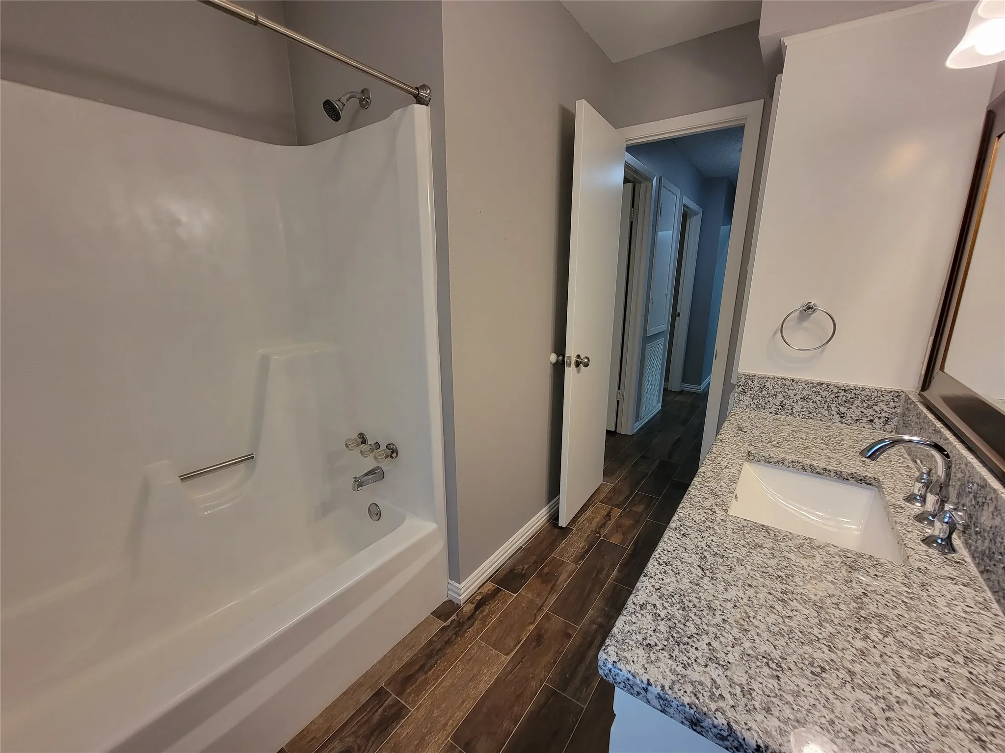 White bathtub with integrated shower, chrome fixtures, and a curved shower rod