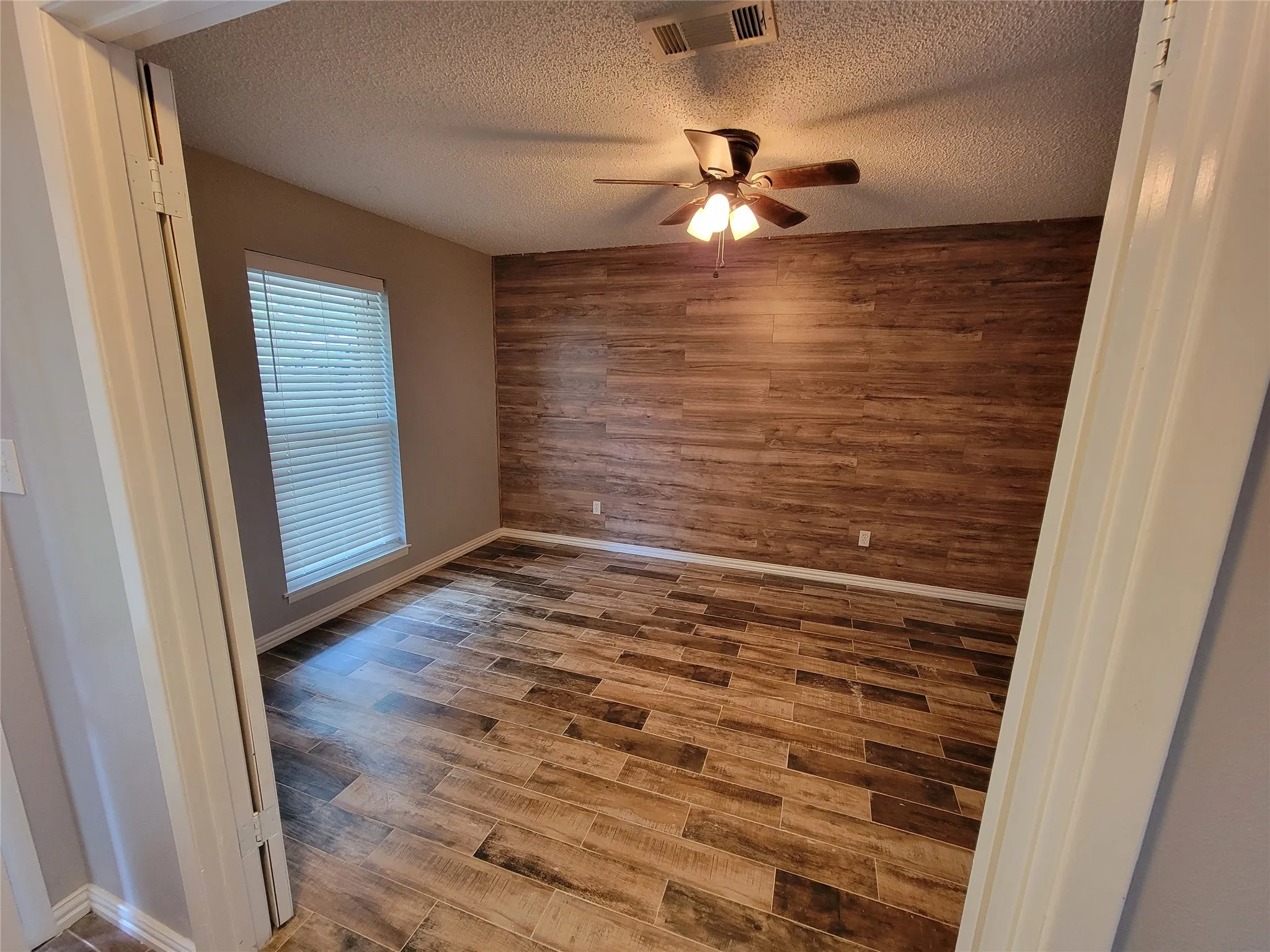 Wood-finish accent wall paired with wood-finish flooring