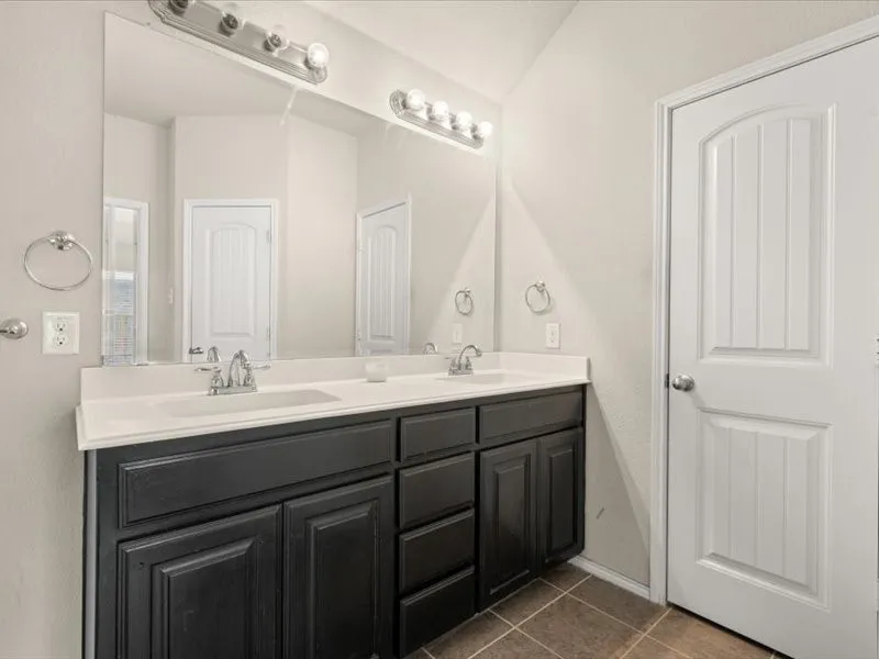 Kitchen featuring dark cabinetry, granite countertops, stainless steel appliances, and a tiled backsplash