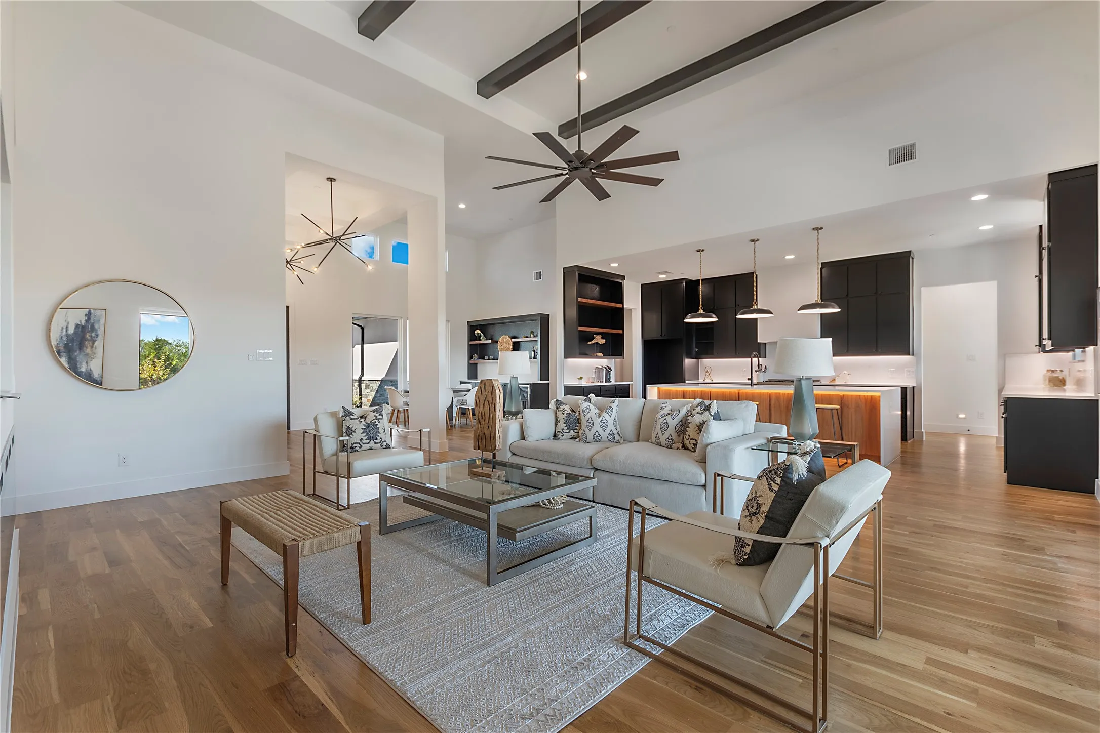 Vaulted ceiling with exposed beams, wood-finish flooring, open concept layout, recessed lighting, and a kitchen island with integrated lighting