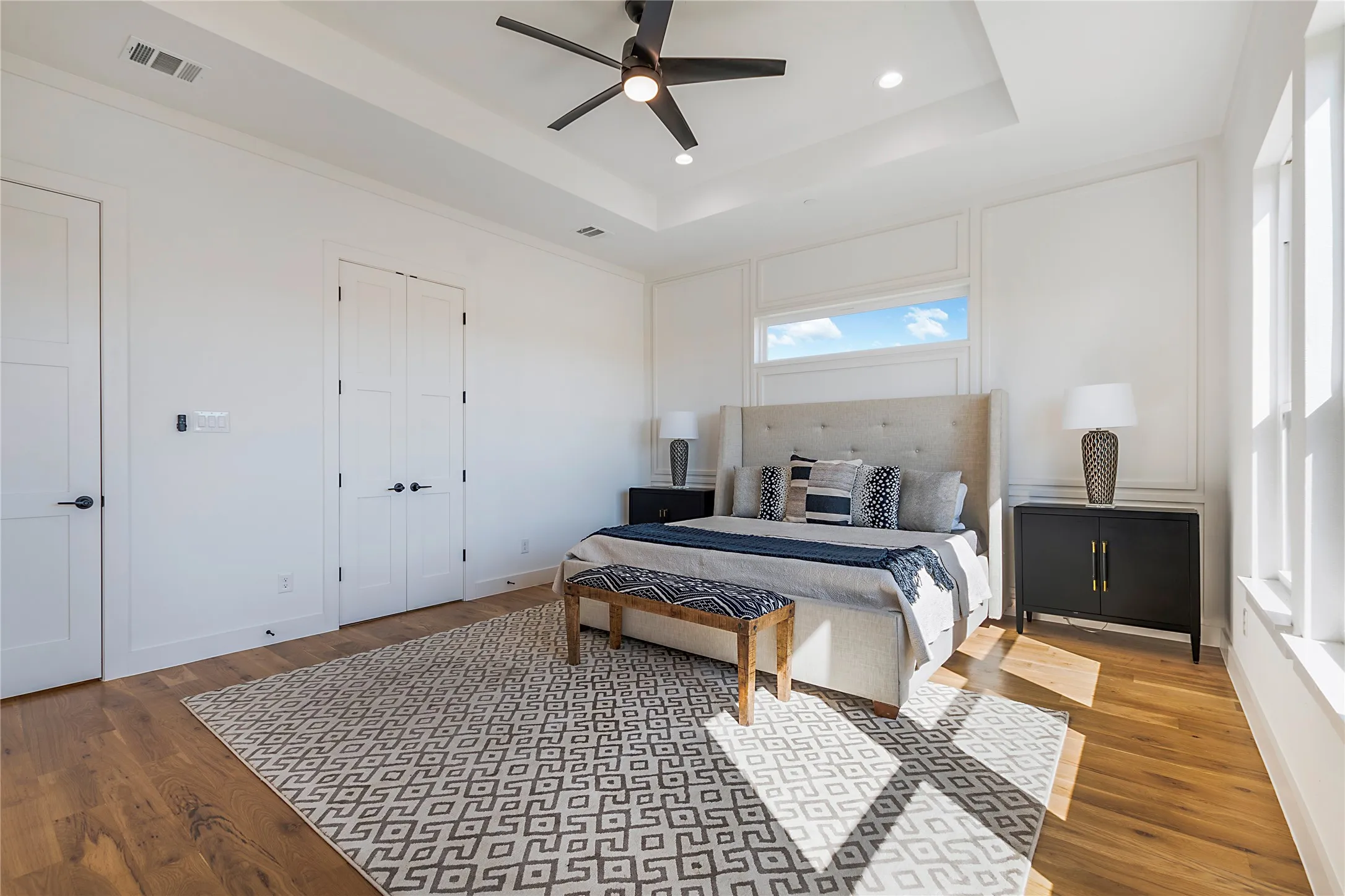 Recessed lighting and a ceiling fan complement the tray ceiling