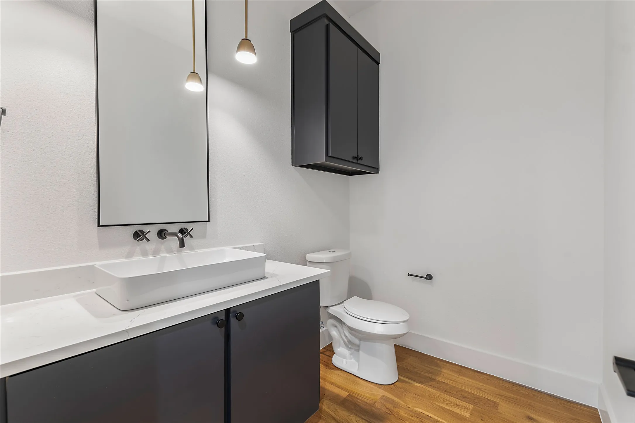 Modern vanity with a rectangular vessel sink, wall-mounted faucet, and matte black cabinetry
