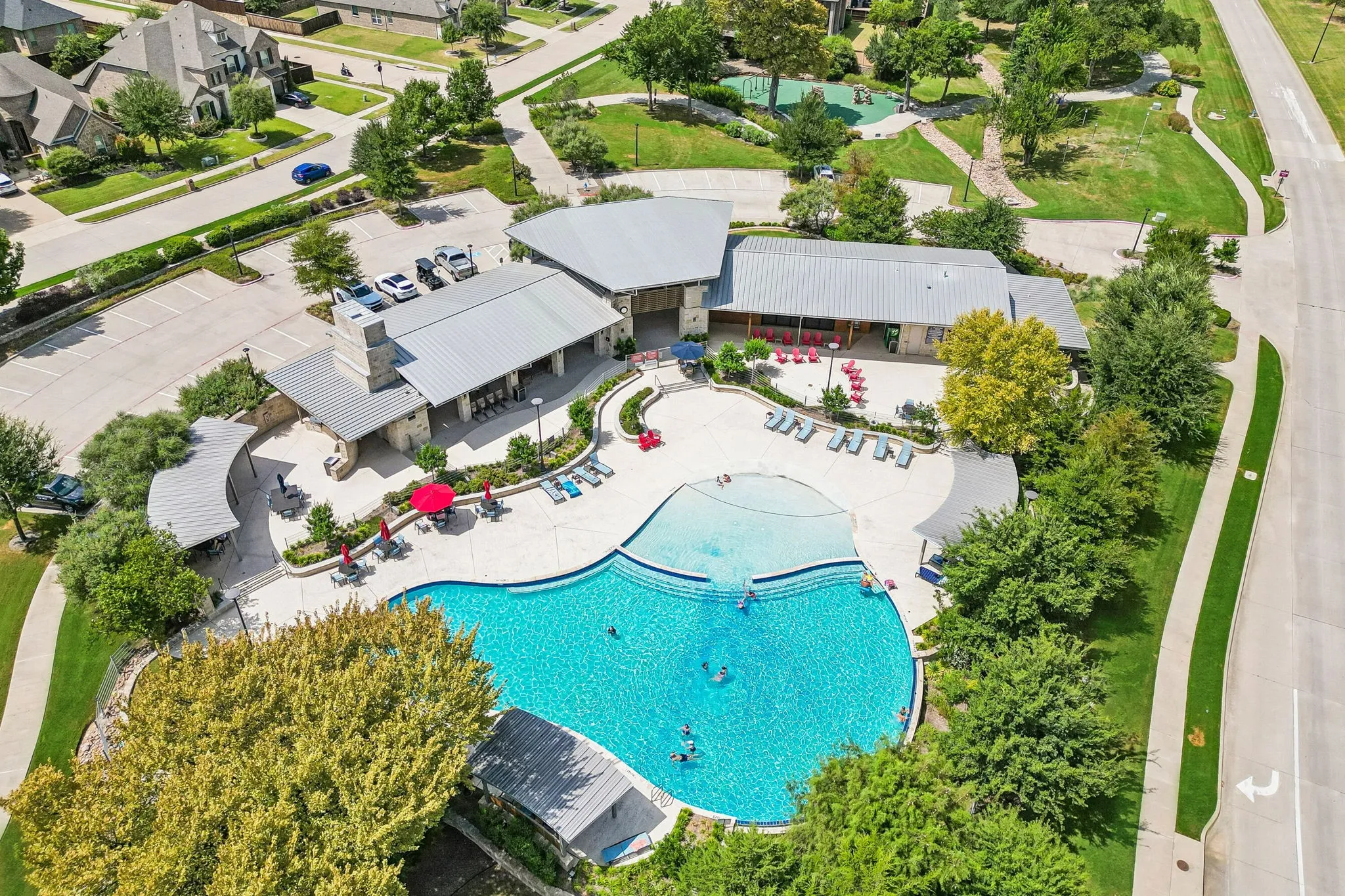 Neighborhood amenity center featuring a resort-style swimming pool with sun shelf entry, expansive gathering spaces, and a covered patio