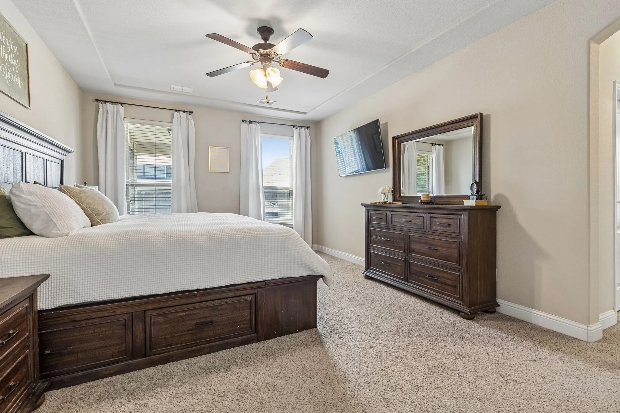 The primary bedroom features a tray ceiling and 2 tall windows