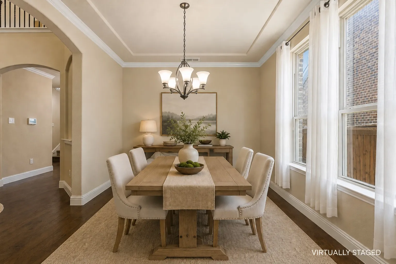 The formal dining room features 2 large windows and a chandelier.