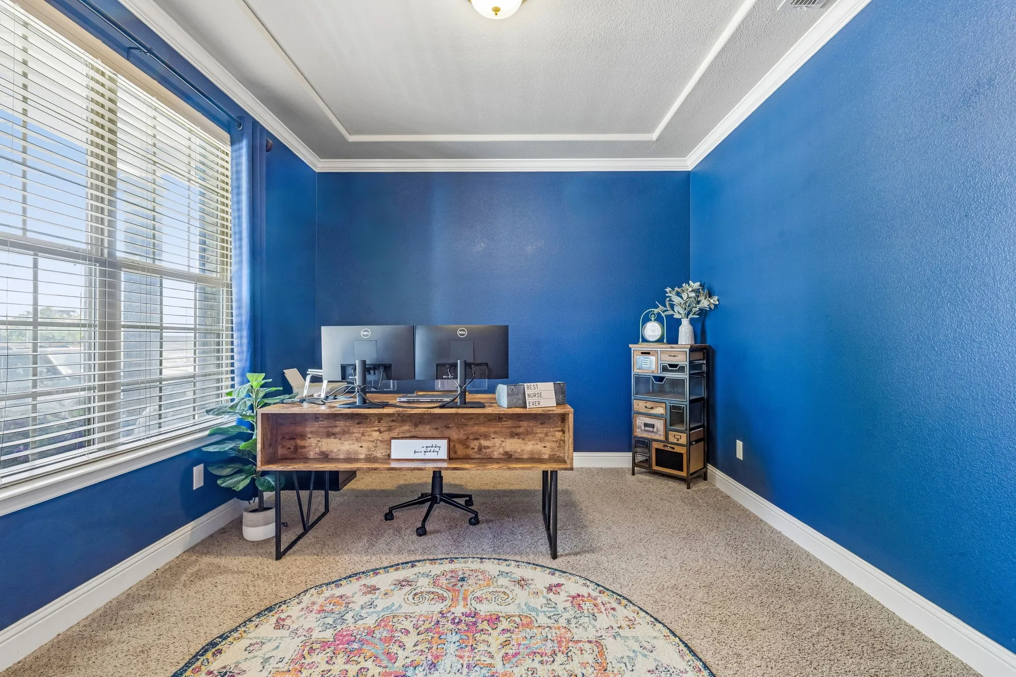 Home office with crown moulding and plenty of natural light.