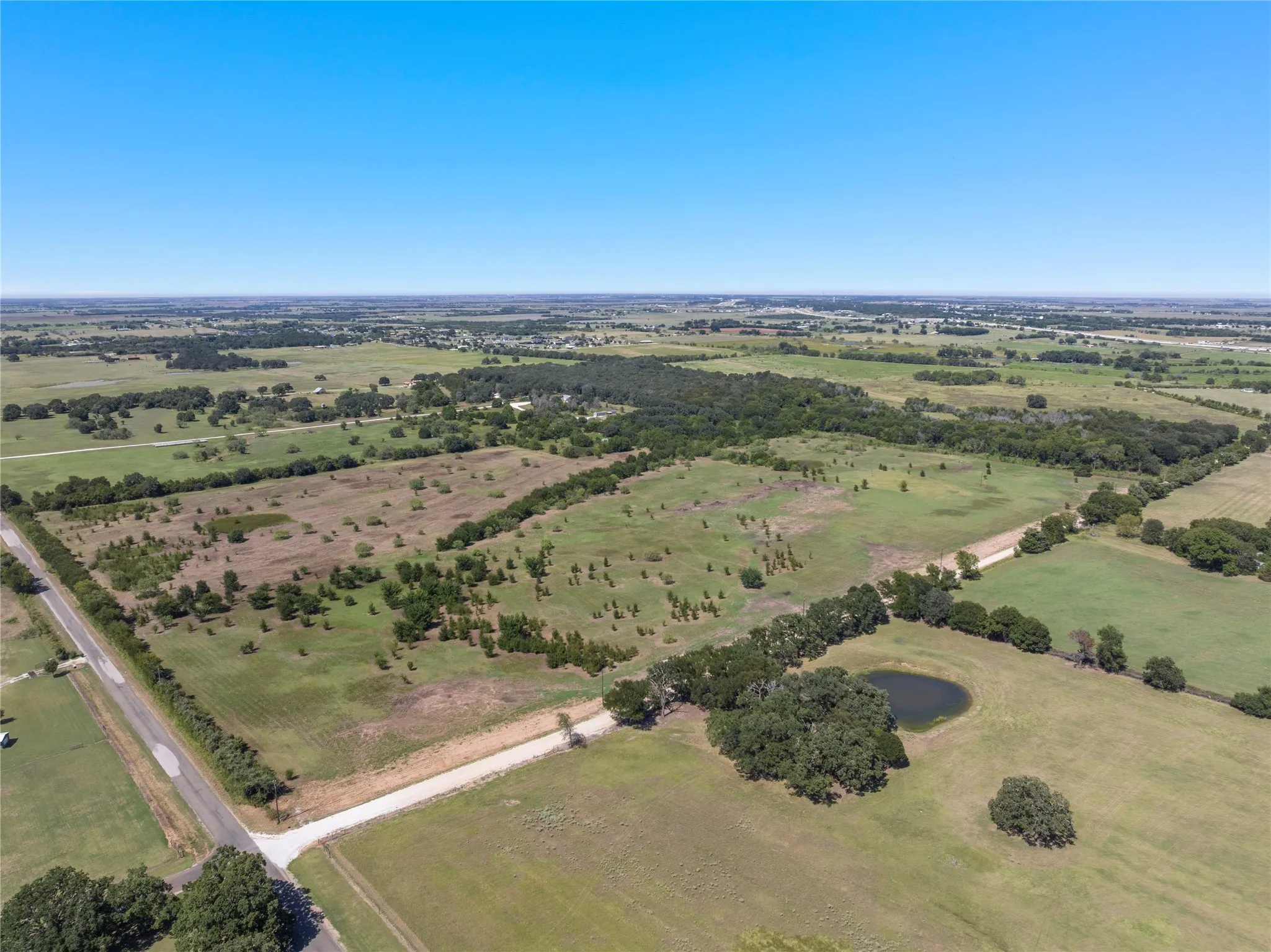 Expansive acreage featuring natural landscape, a pond, and perimeter tree lines